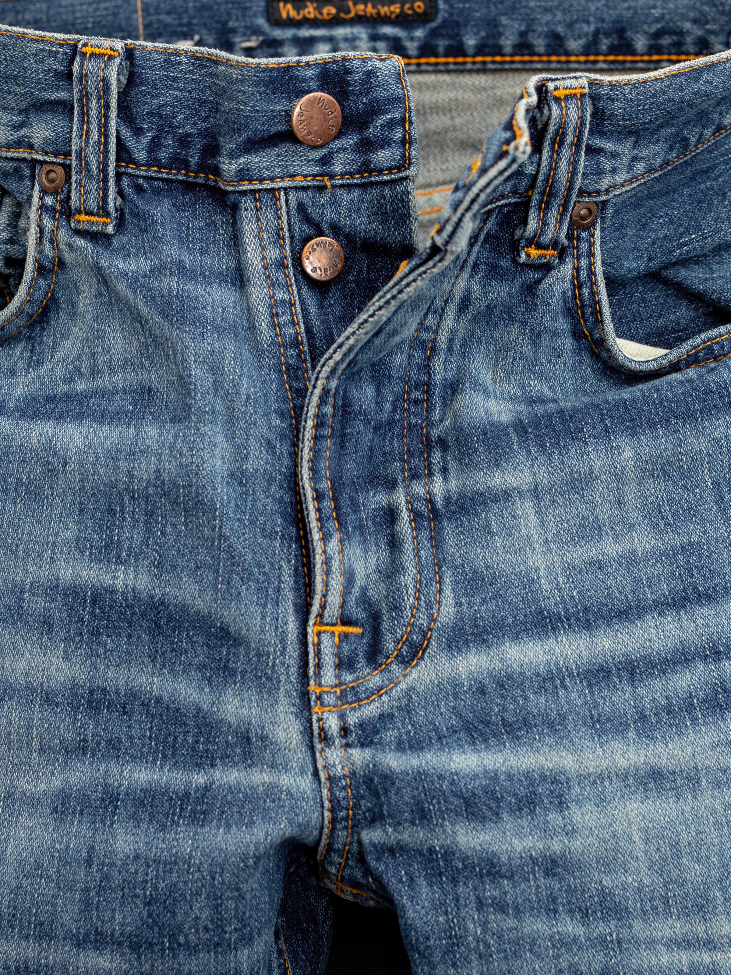 Nudie Jeans Steady Eddie II Muted Tracks, close-up of the button fly showing the copper trims and faded denim texture.