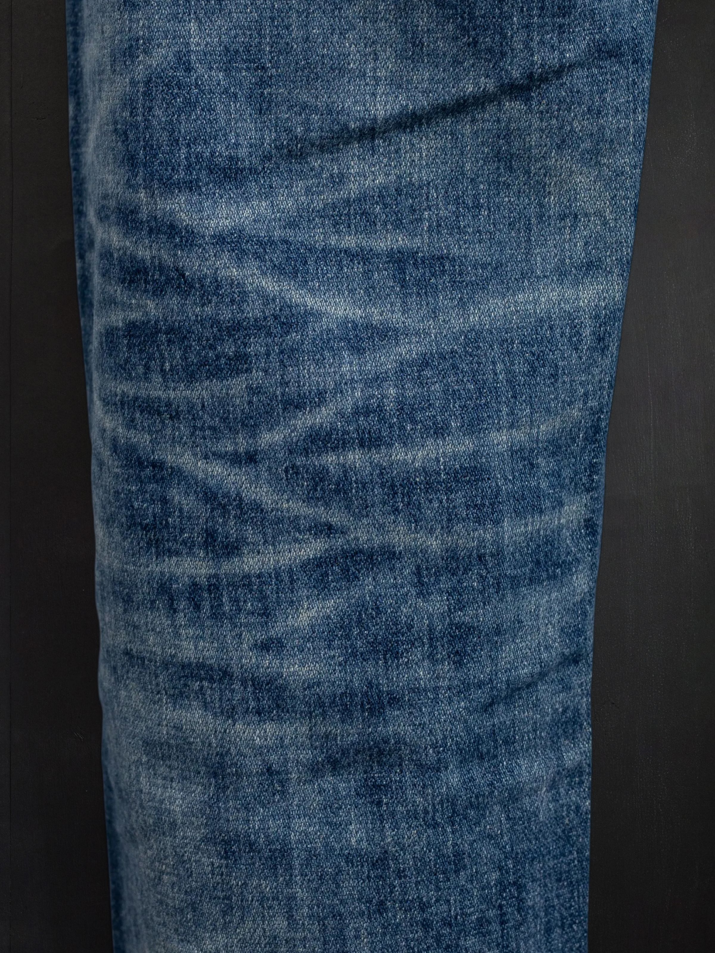 Nudie Jeans Lean Dean Salty Tracks, men's slim tapered jeans, close-up of the fabric showing the wash and wear marks.