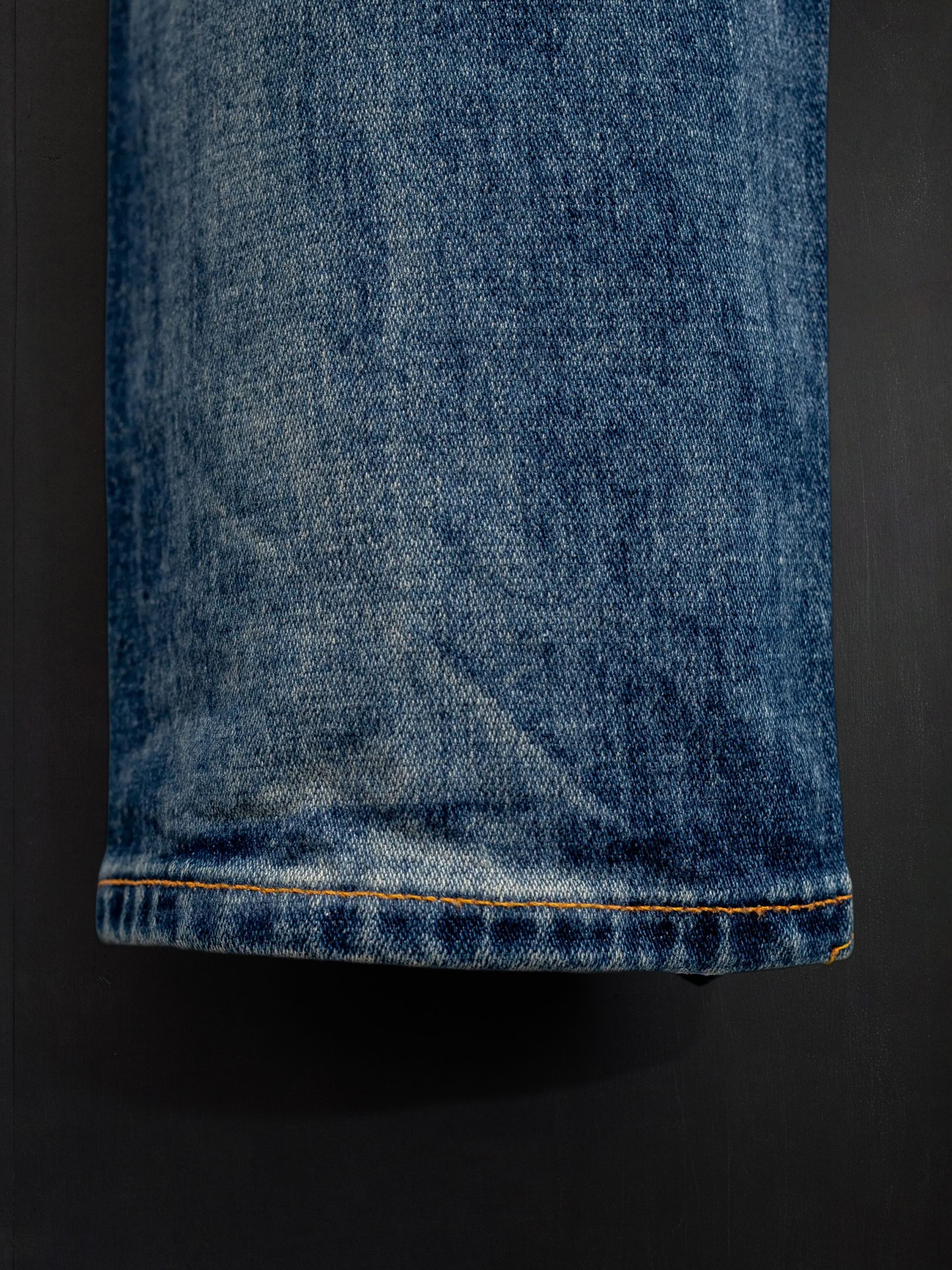 Nudie Jeans Lean Dean Salty Tracks, men's slim tapered fit jeans, showing a close-up of the hem and denim texture.