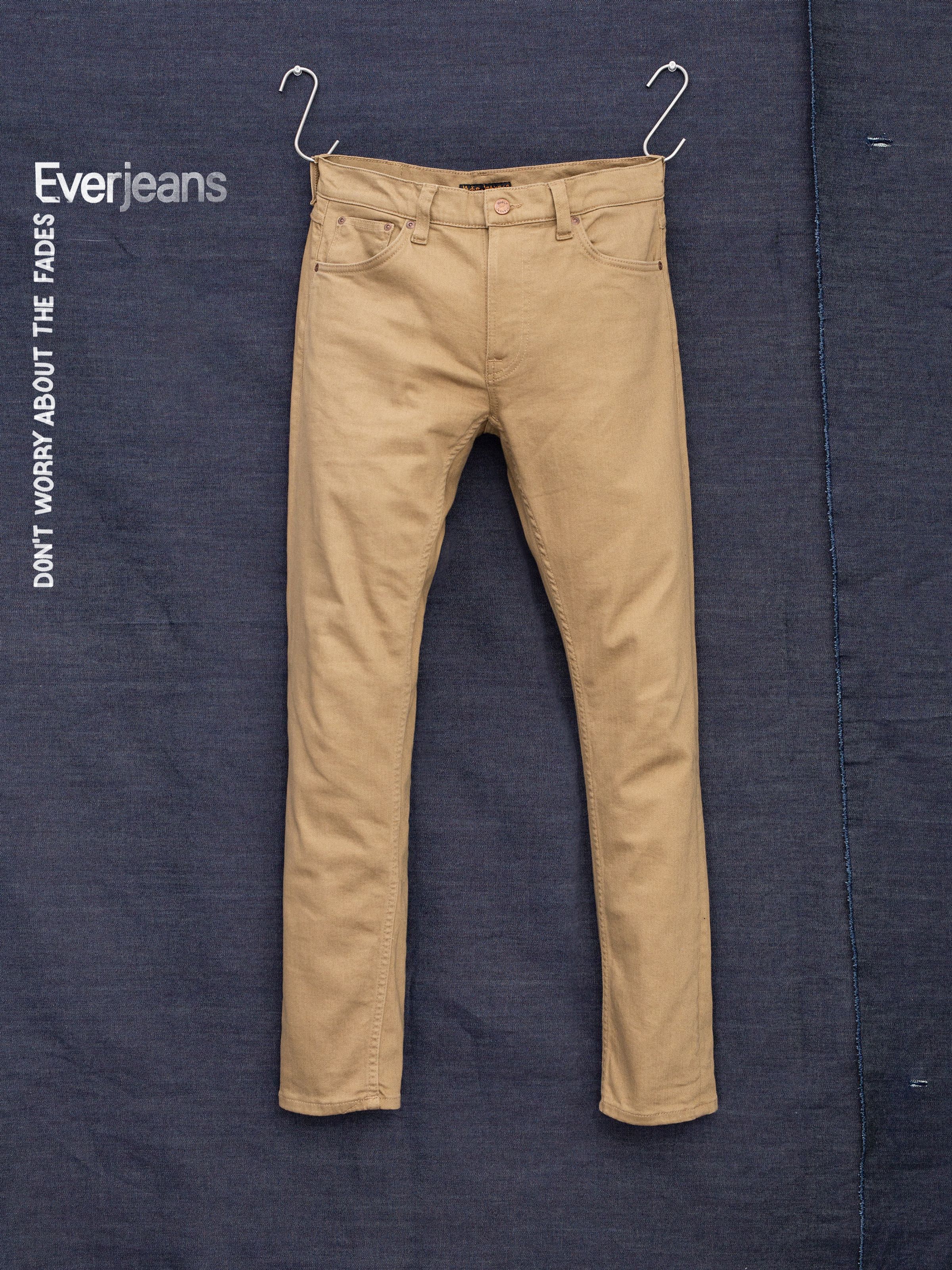 Nudie Jeans Lean Dean Everlion, men's slim tapered jeans in a tobacco color, hanging flat against a denim backdrop.