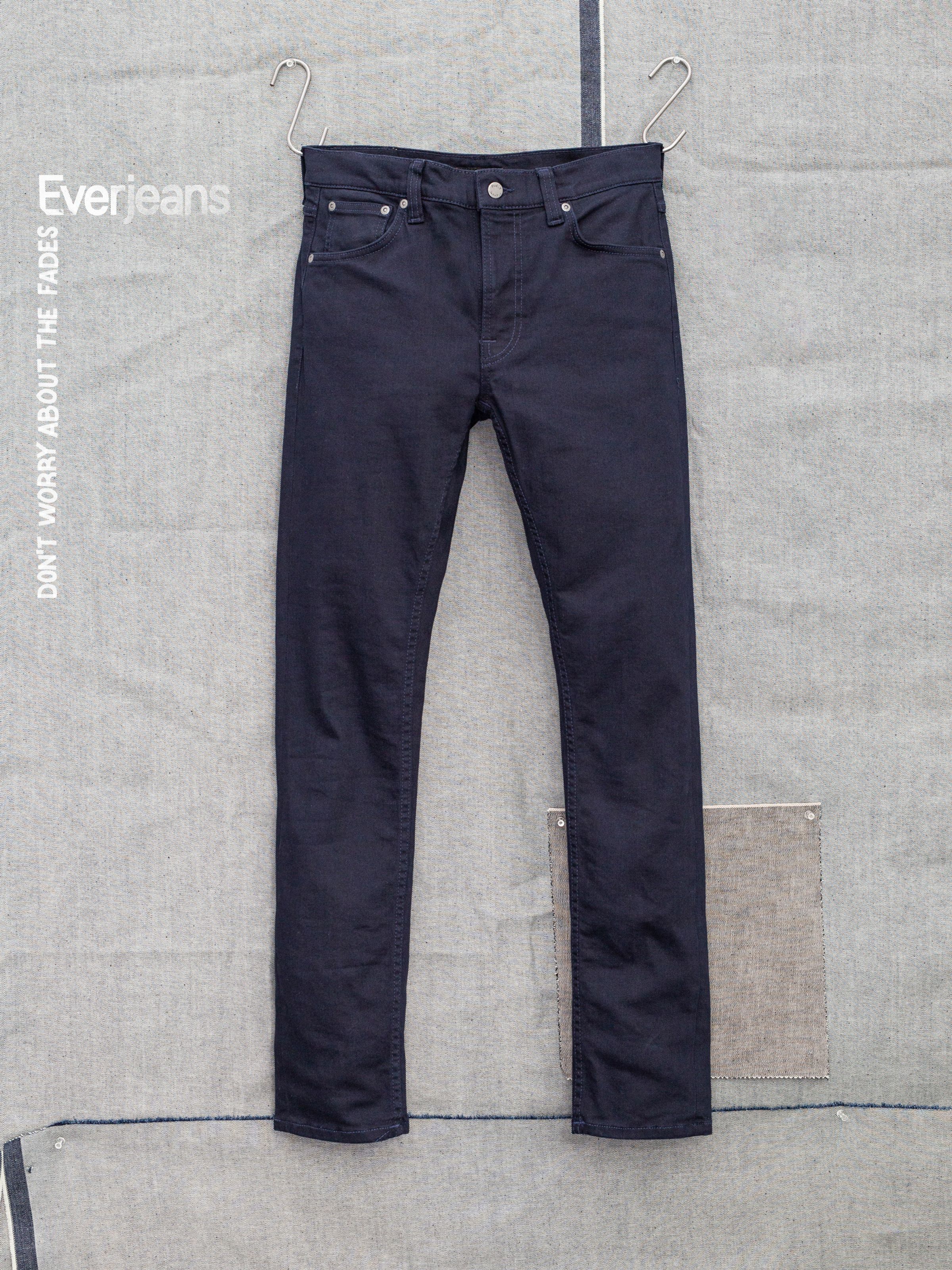 Nudie Jeans Lean Dean Everblue, men's slim tapered jeans hanging against a fabric backdrop.