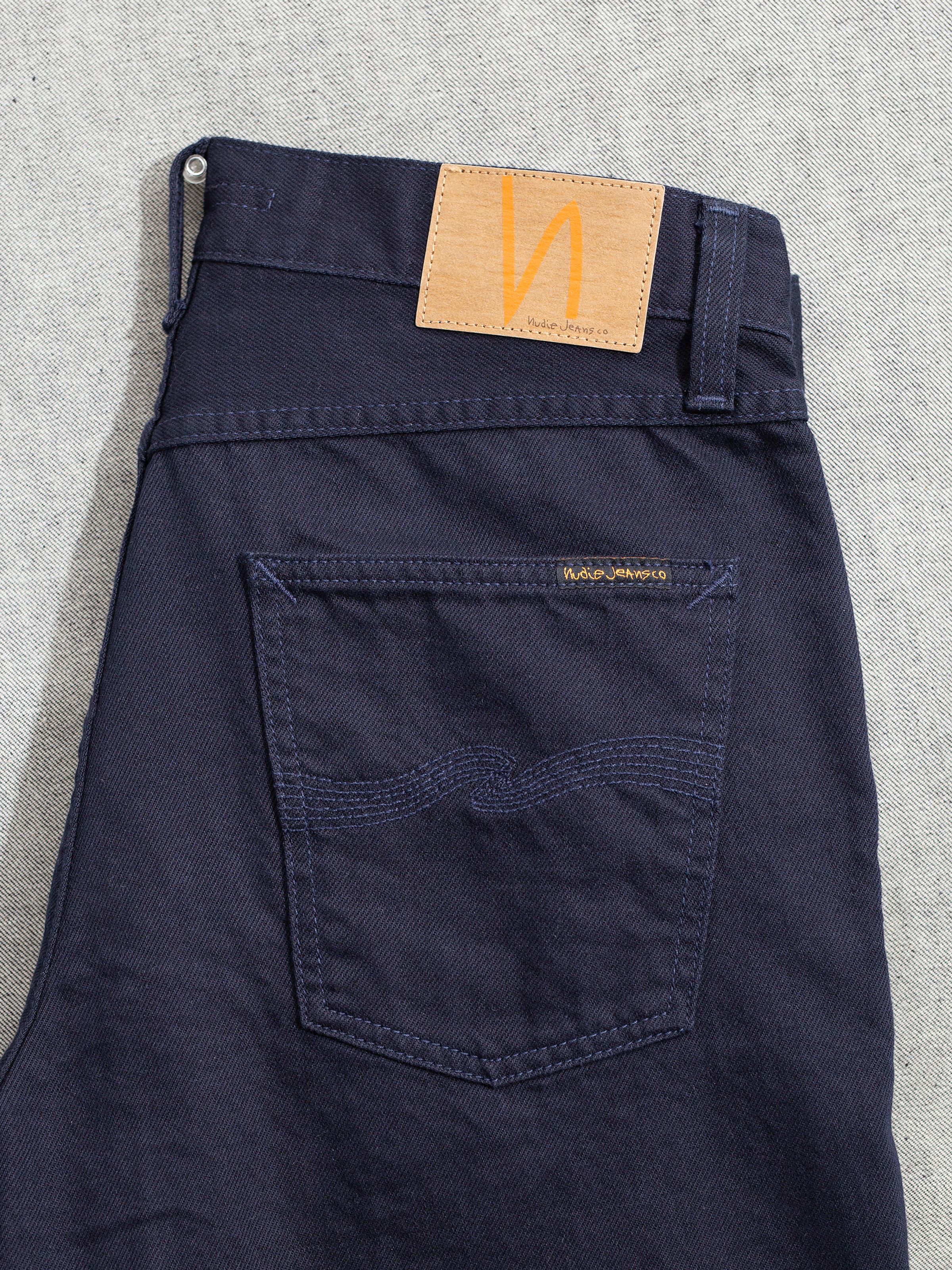 Nudie Jeans Lean Dean Everblue, men's slim tapered jeans, close-up of the back pocket showing the stitching and jacron patch.