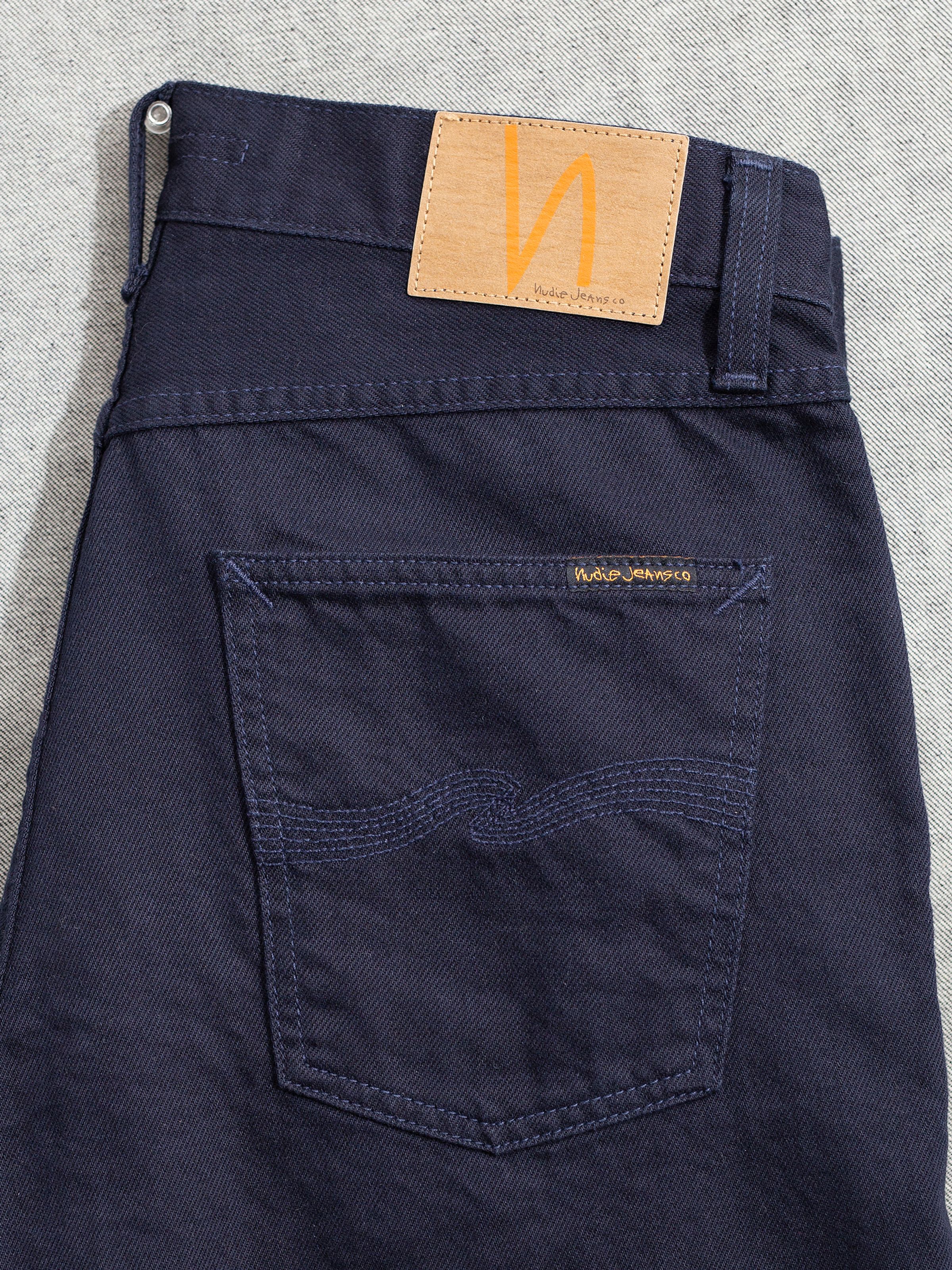 Nudie Jeans Gritty Jackson Everblue, men's regular fit jeans, showing a close-up of the back pocket and jacron patch.