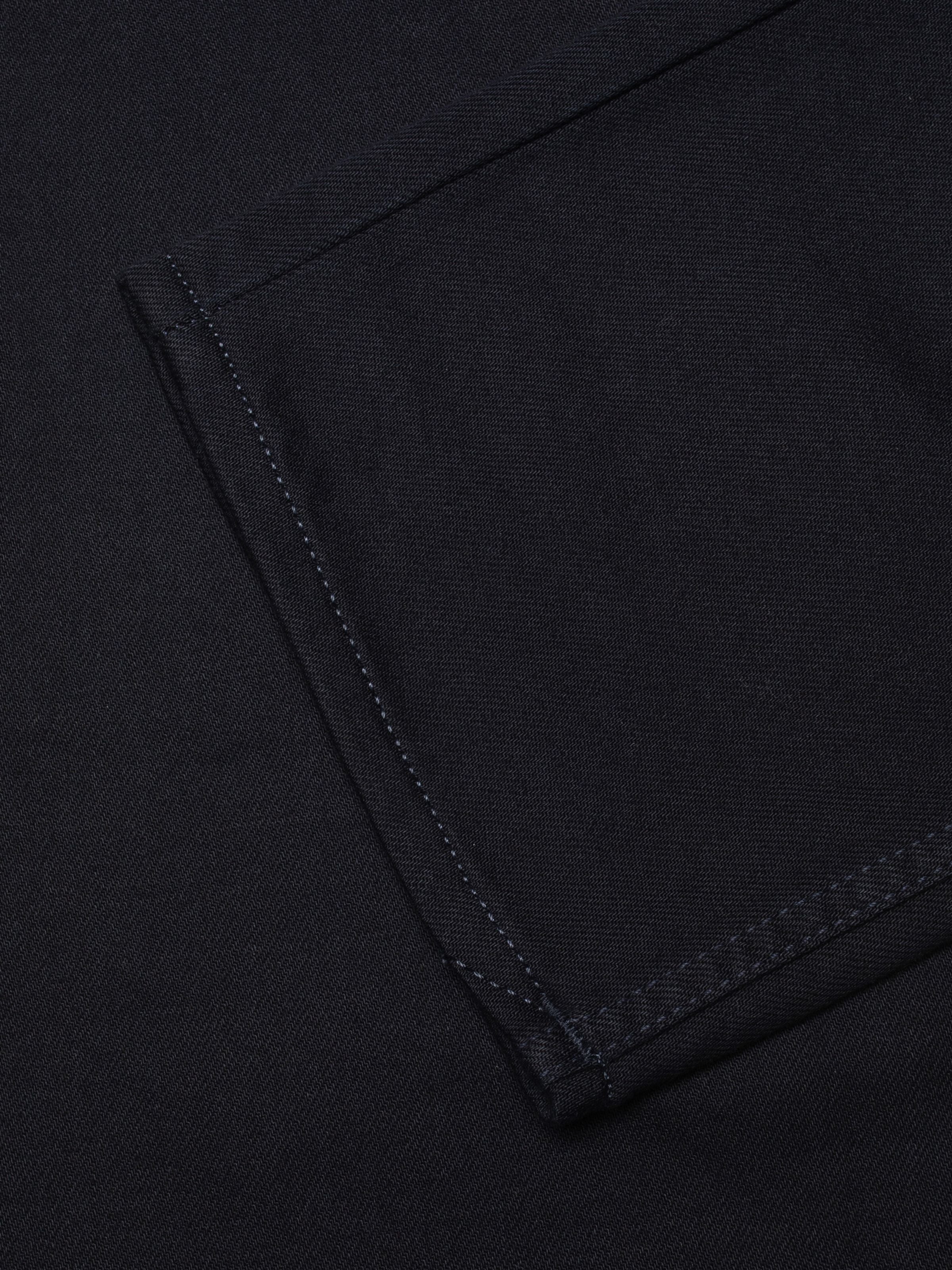 Nudie Jeans Rad Rufus Everblue, men's regular fit jeans, close-up of the dark blue denim and back pocket stitching detail.