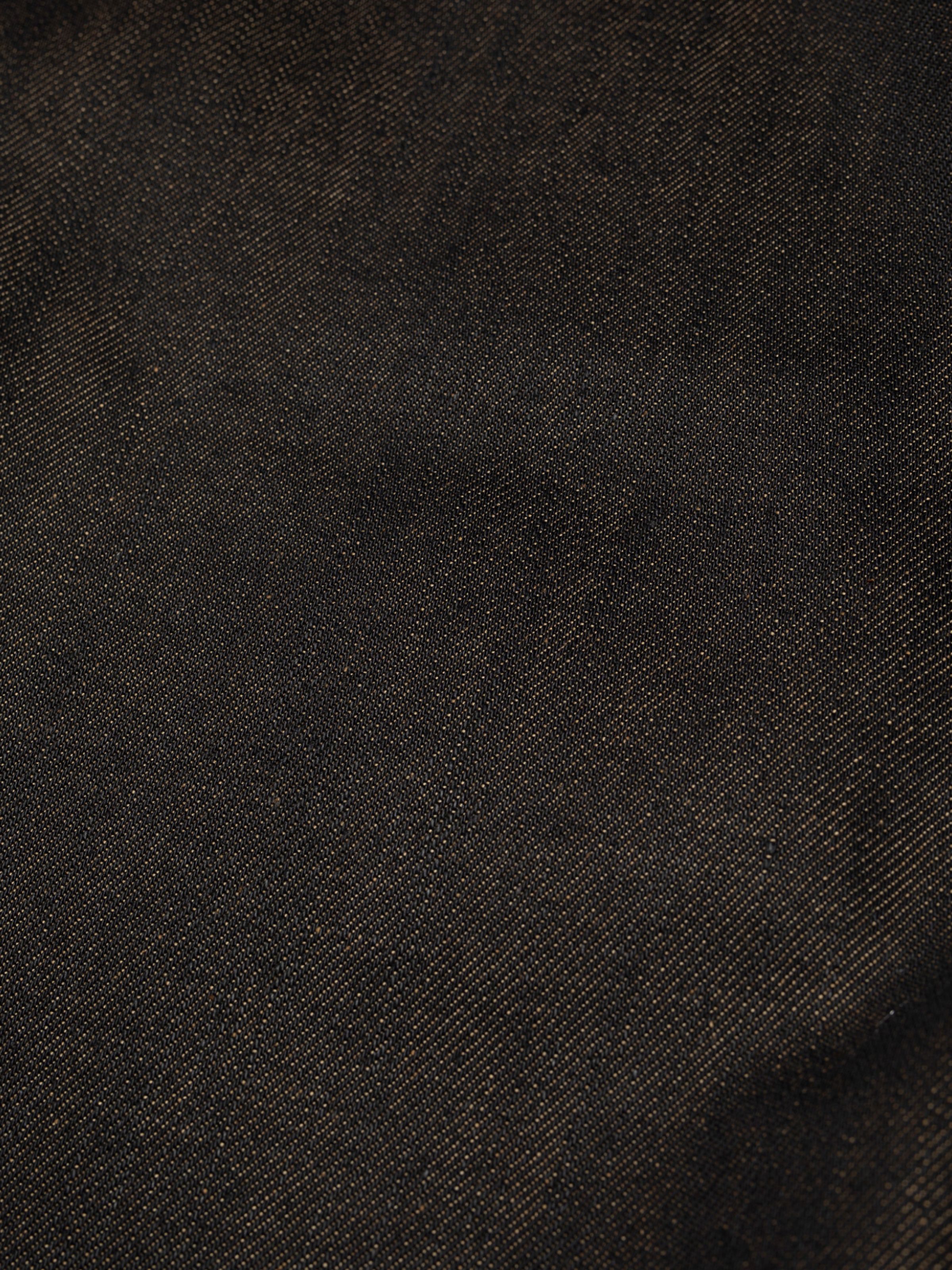 Nudie Jeans Flare Glenn in Dry Blue, Nahaufnahme des rigiden Deadstock-Denims in schwärzlichem Indigo.