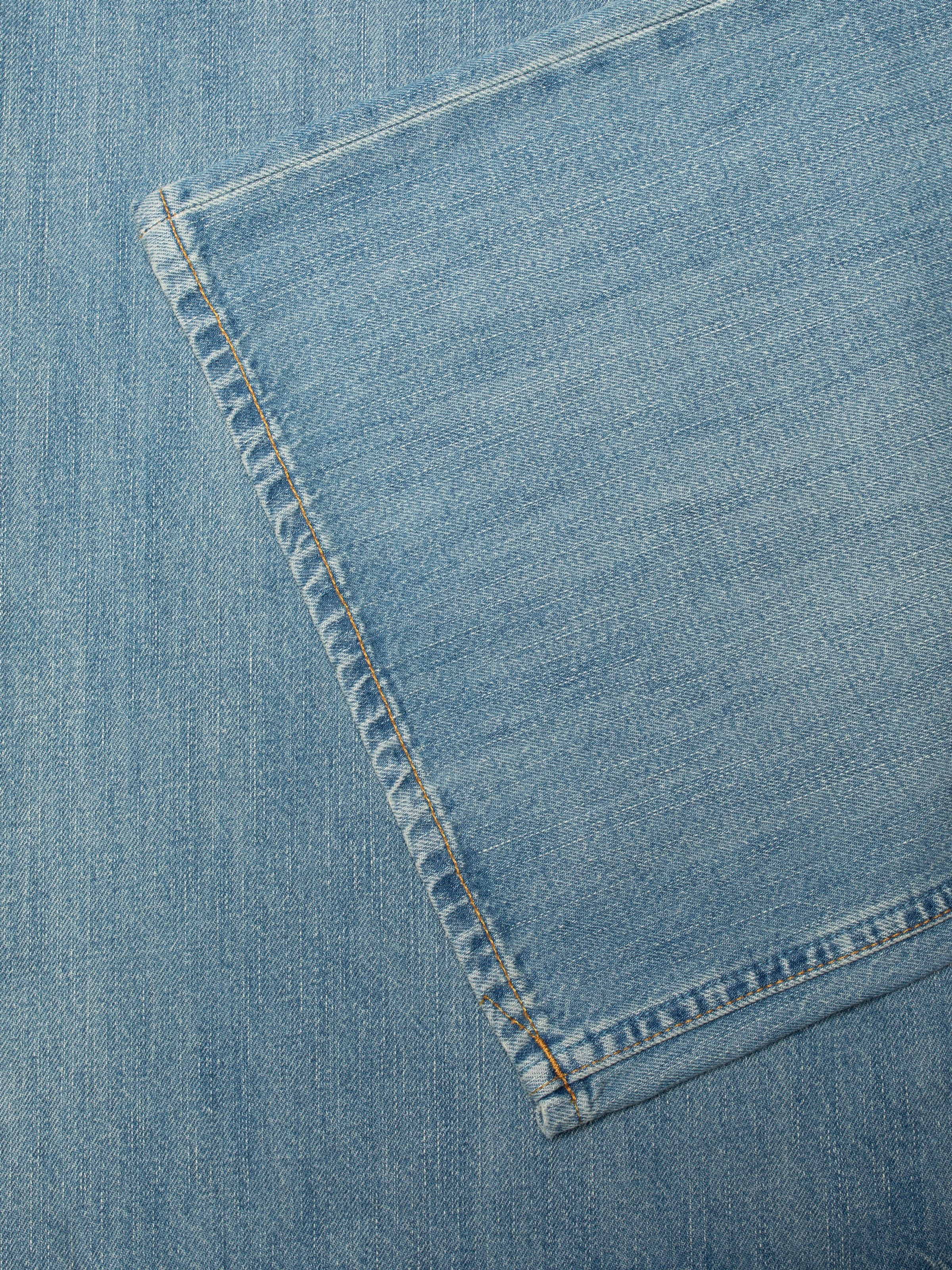 Nudie Jeans Sonic Sue Blue Wave, women's loose fit jeans in a light blue wash, close-up of the hem and fabric detail.