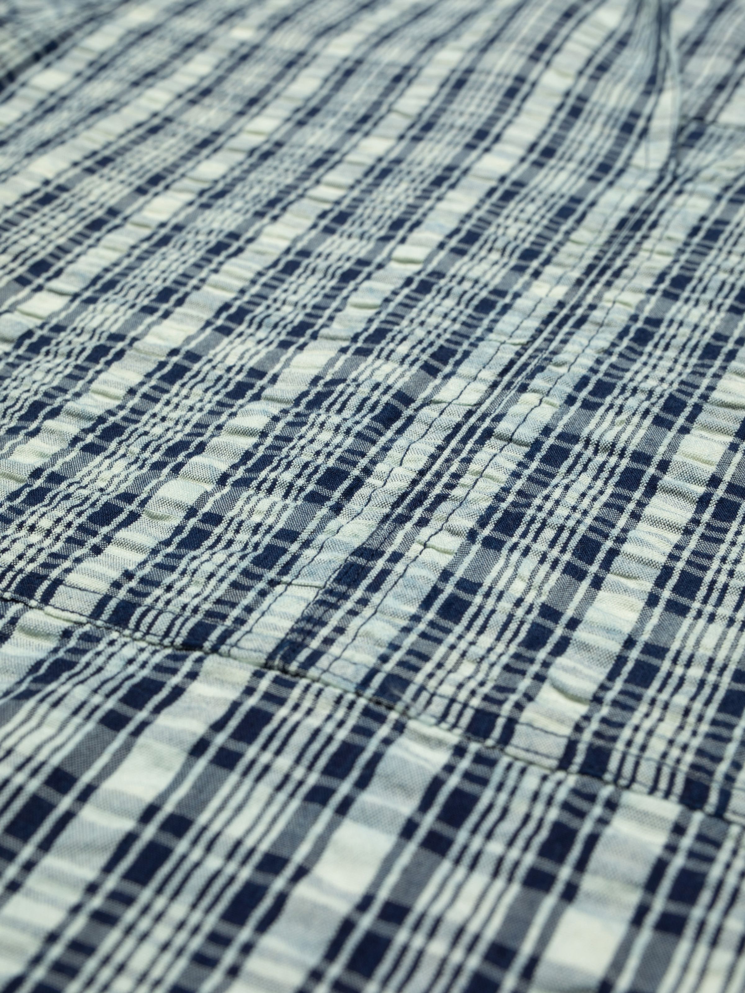 Nudie Jeans Ronja Dress Indigo Seersucker, close-up of the blue and off-white indigo yarn check seersucker fabric.