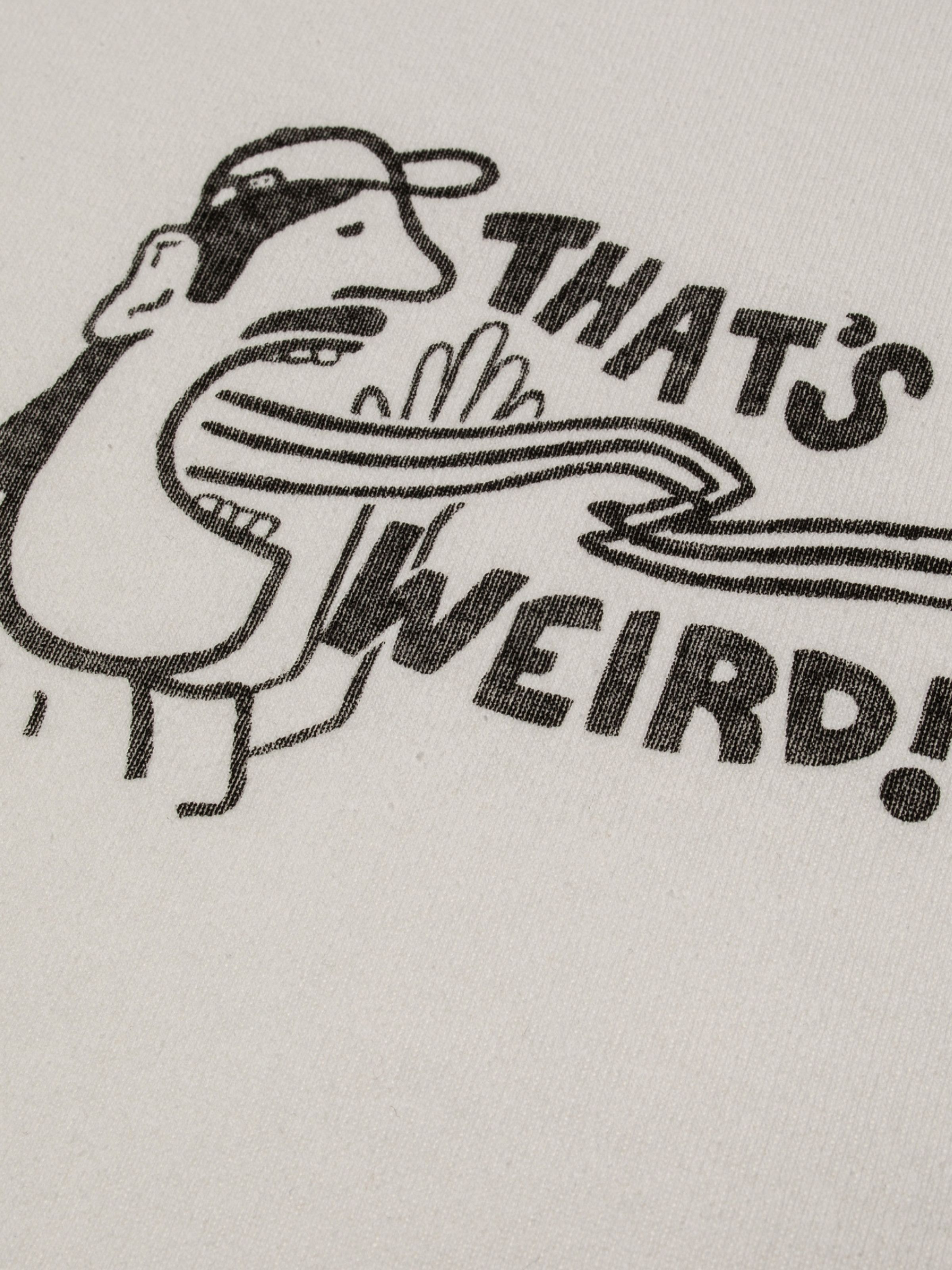 Nudie Jeans Eve T-Shirt That's Weird in Offwhite, close-up of the 'THAT'S WEIRD!' graphic on organic rib knit cotton.