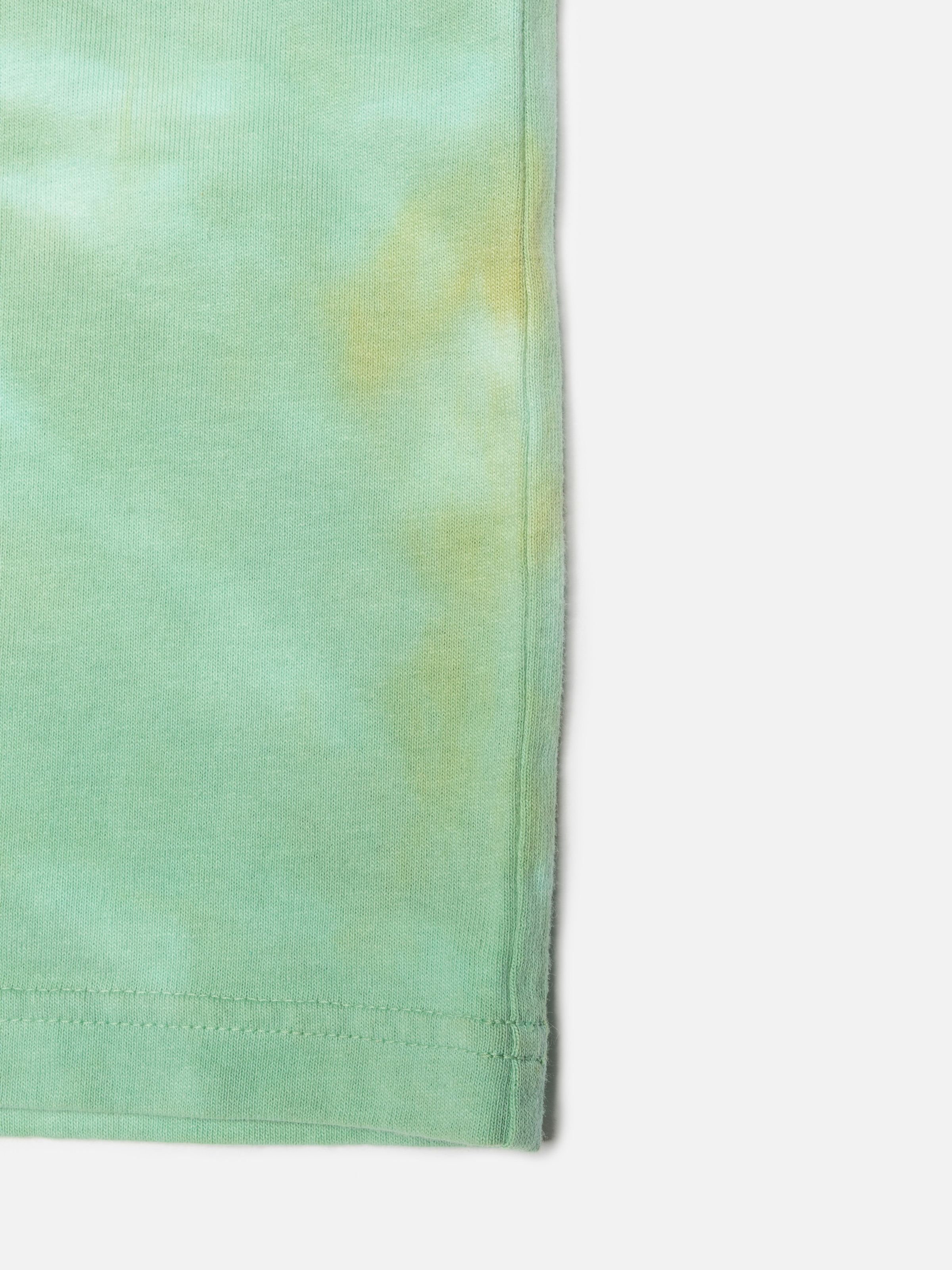 Nudie Jeans Rita T-Shirt Take It Easy, close-up of the green tie-dye organic cotton jersey fabric showing the hem.