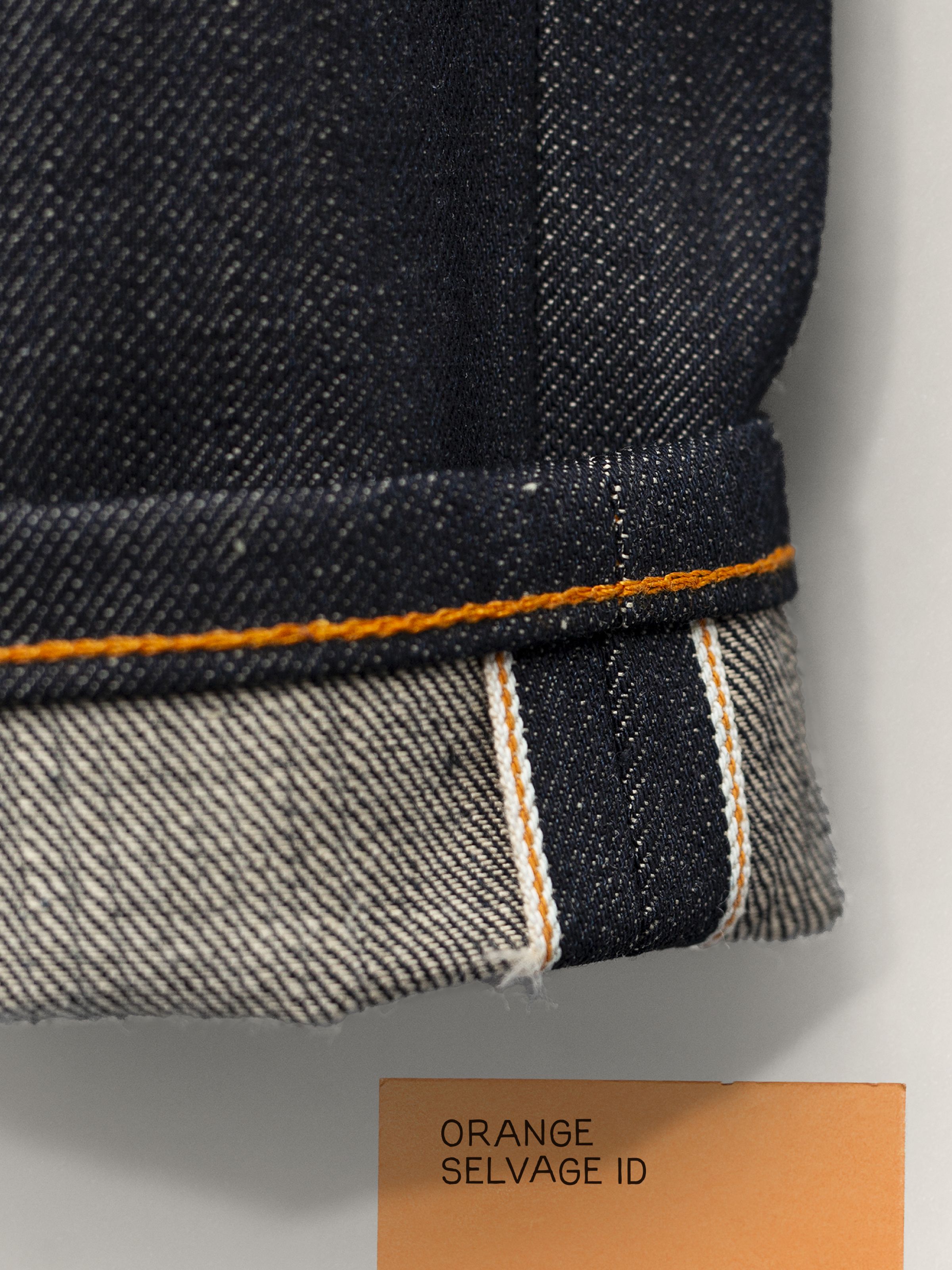 Nudie Jeans Regular Alf Dry Selvage, Nahaufnahme des umgeschlagenen Saums mit der orangefarbenen Selvedge-ID-Linie.