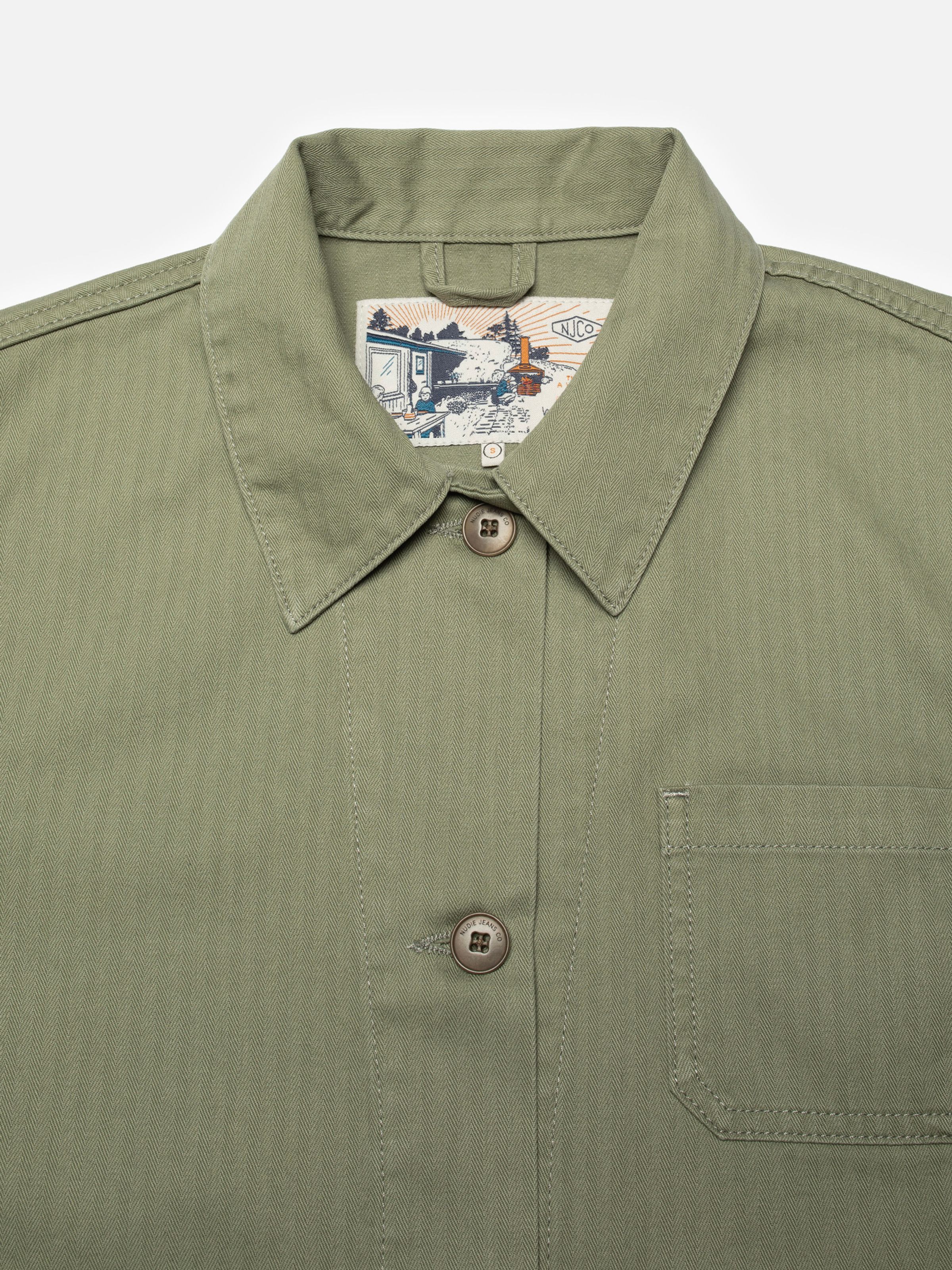 Nudie Jeans Lovis Herringbone Jacket in Pale Green, a close-up of the collar showing the fabric texture and neck label.