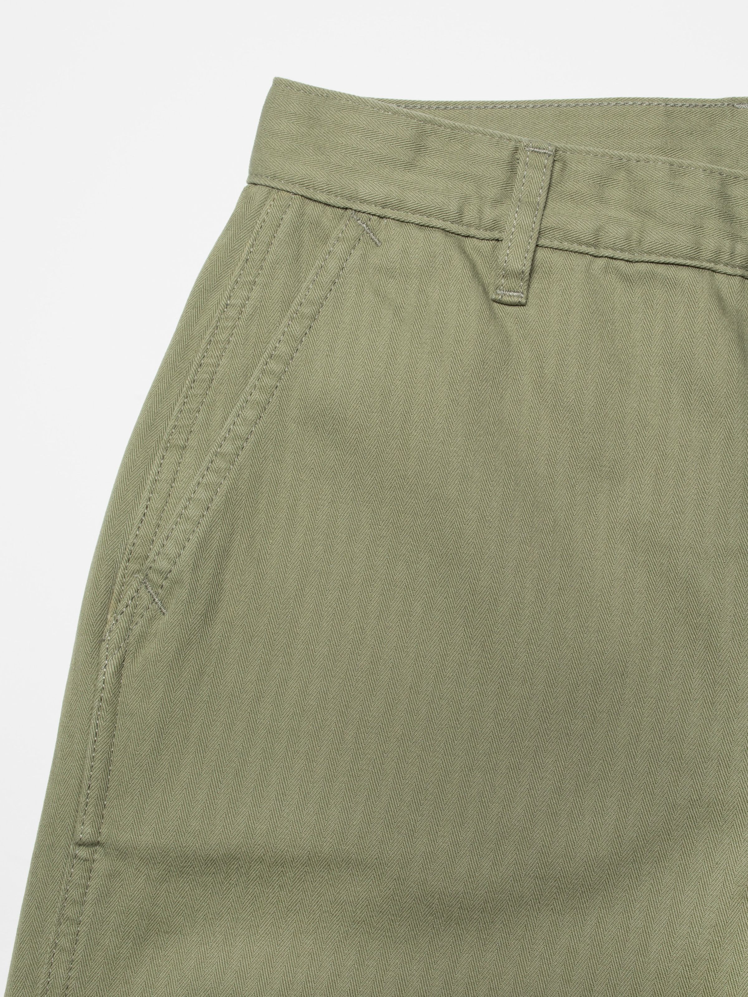 Nudie Jeans Wendy Herringbone Pale Green, women's wide-leg pants, close-up of the front pocket and waistband detail.