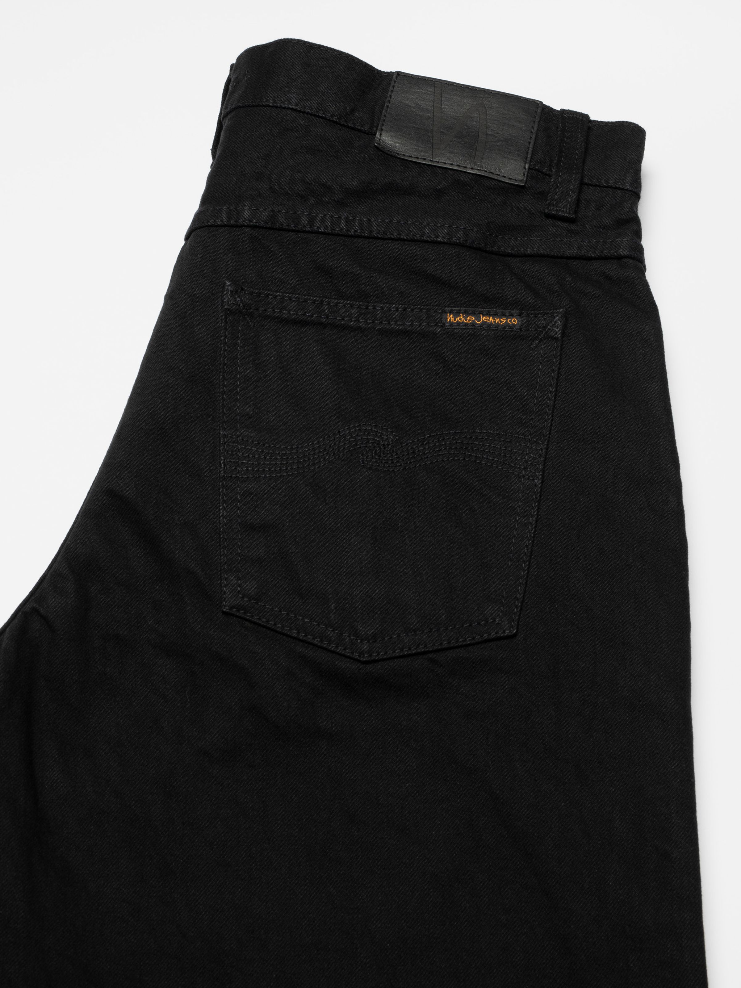 Nudie Jeans Loud Larry Black Water, men's loose fit jeans in black denim, showing a close-up of the back pocket.