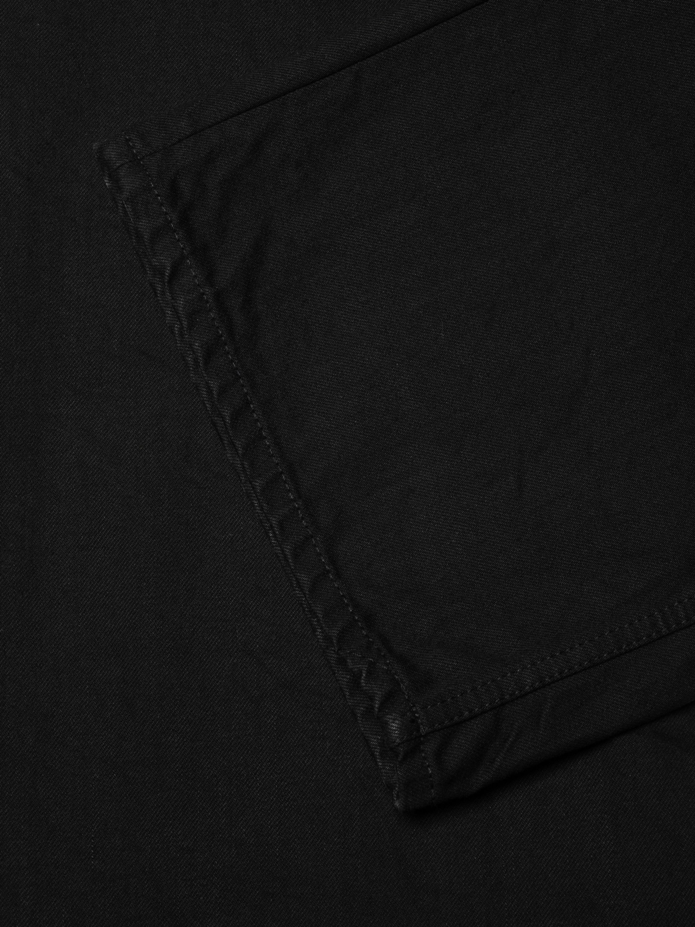 Nudie Jeans Loud Larry Black Water, a men's loose fit jean in black denim, showing a close-up detail of the hem.
