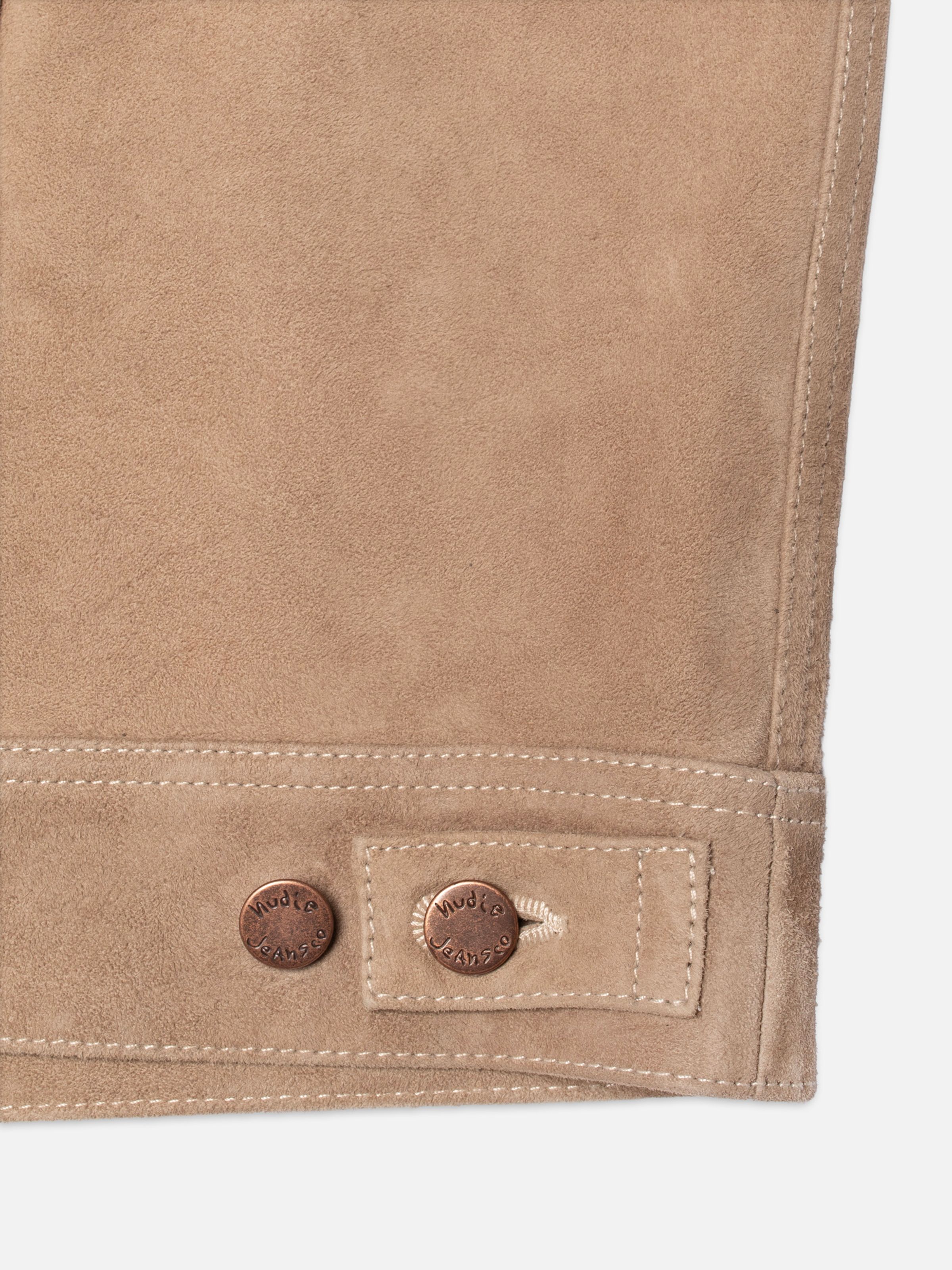 Nudie Jeans Willy Suede Jacket in Mud, close-up of the bottom hem and waist tab with copper logo buttons.