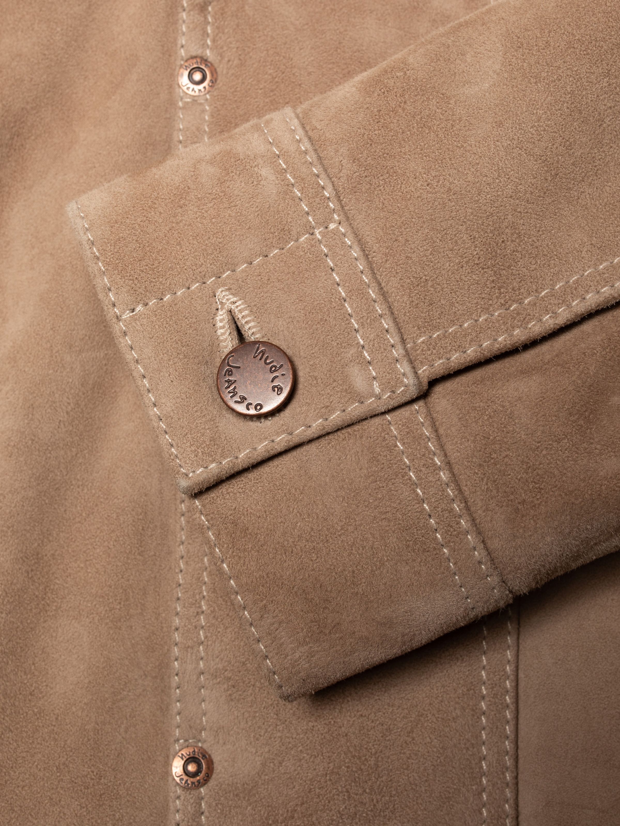Nudie Jeans Willy Suede Jacket Mud, close-up of the sleeve cuff showing the copper logo button.