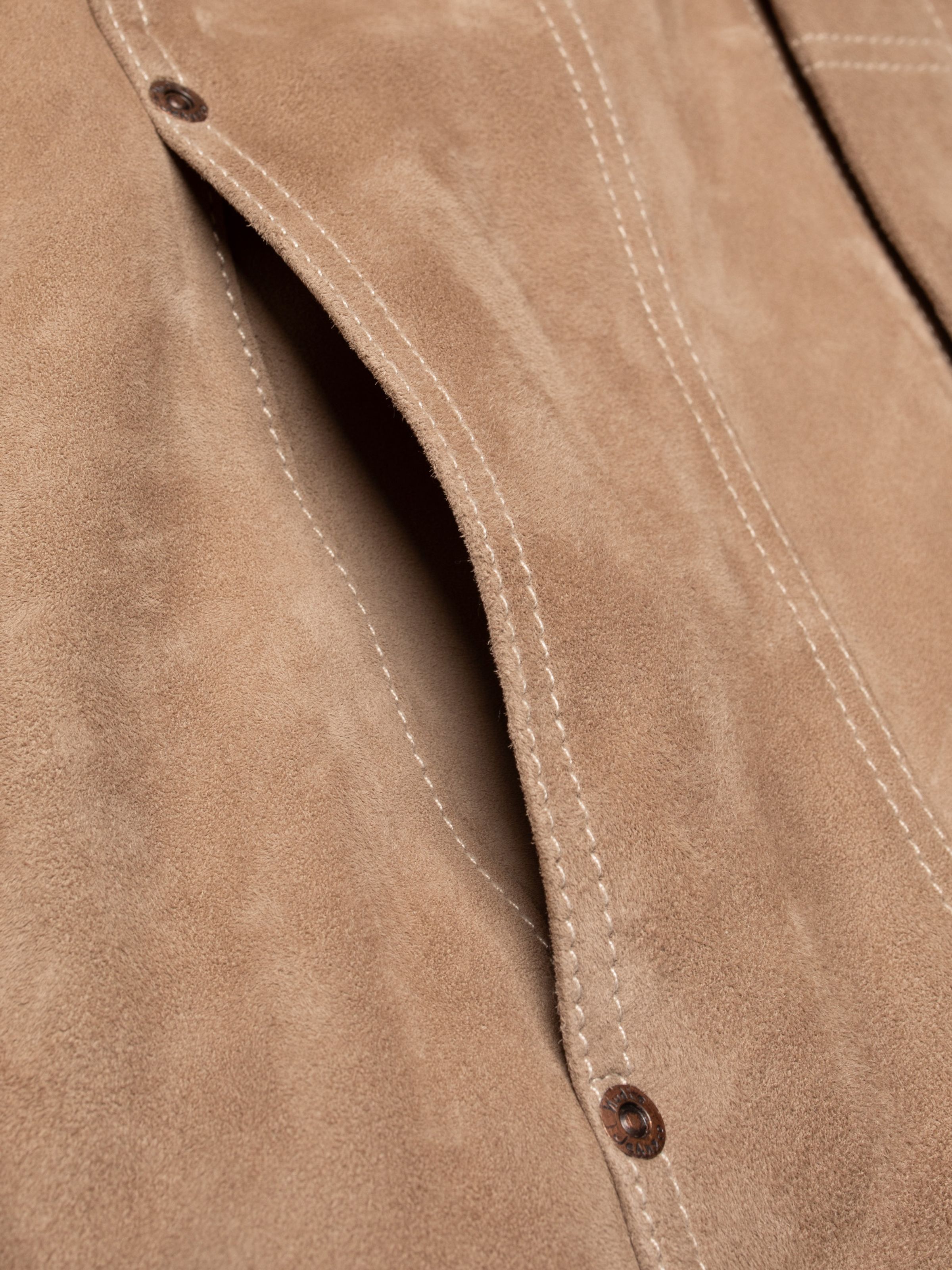 Nudie Jeans Willy Suede Jacket Mud, close-up of the side slip-in pocket showing the sand-colored goat suede texture.
