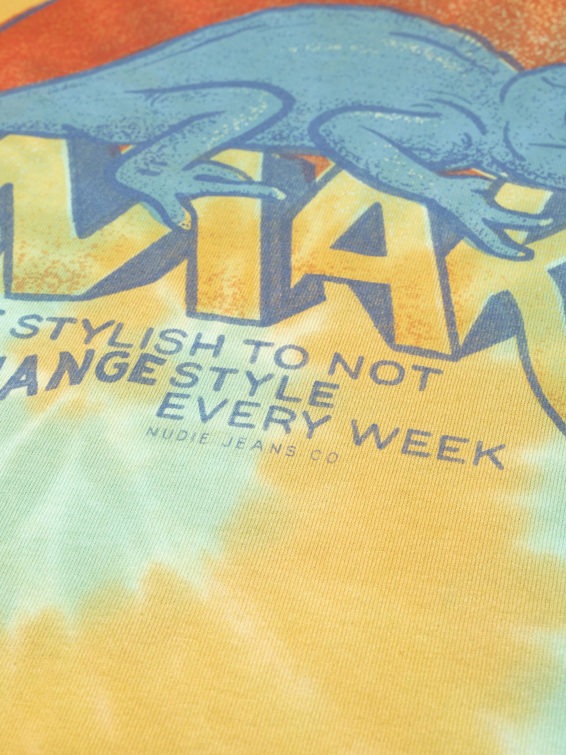 Nudie Jeans Koffe T-Shirt Chameleon Turquoise, close-up of the chest print on organic cotton tie-dye jersey.