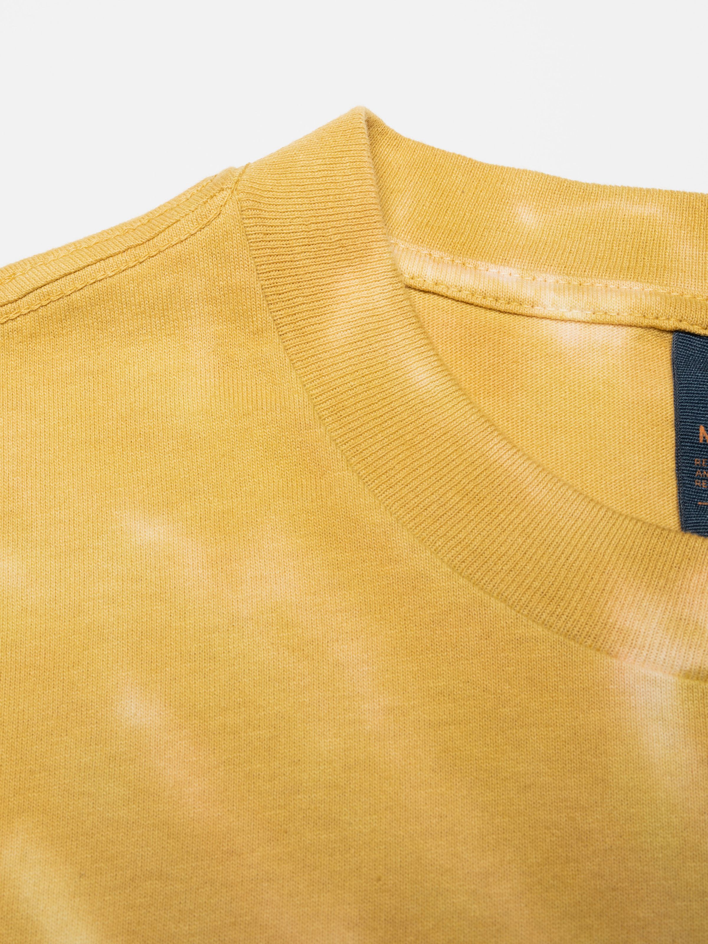 Nudie Jeans Koffe T-Shirt Chameleon Turquoise, close-up of the ribbed crew neck and tie-dye organic cotton fabric.