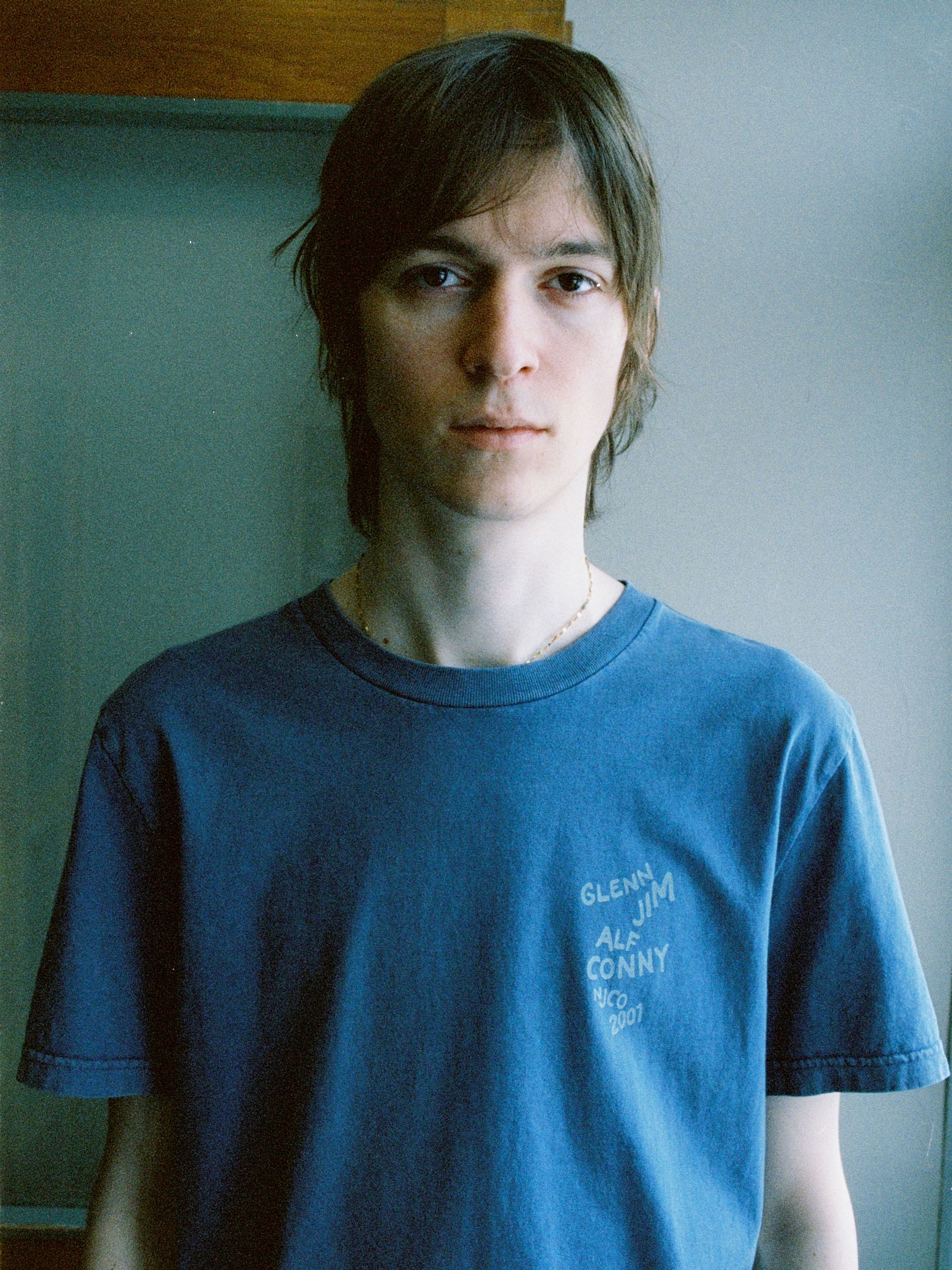 Nudie Jeans Roy T-Shirt OG Line-Up French Blue, men's organic cotton tee shown on a model in a lifestyle portrait.