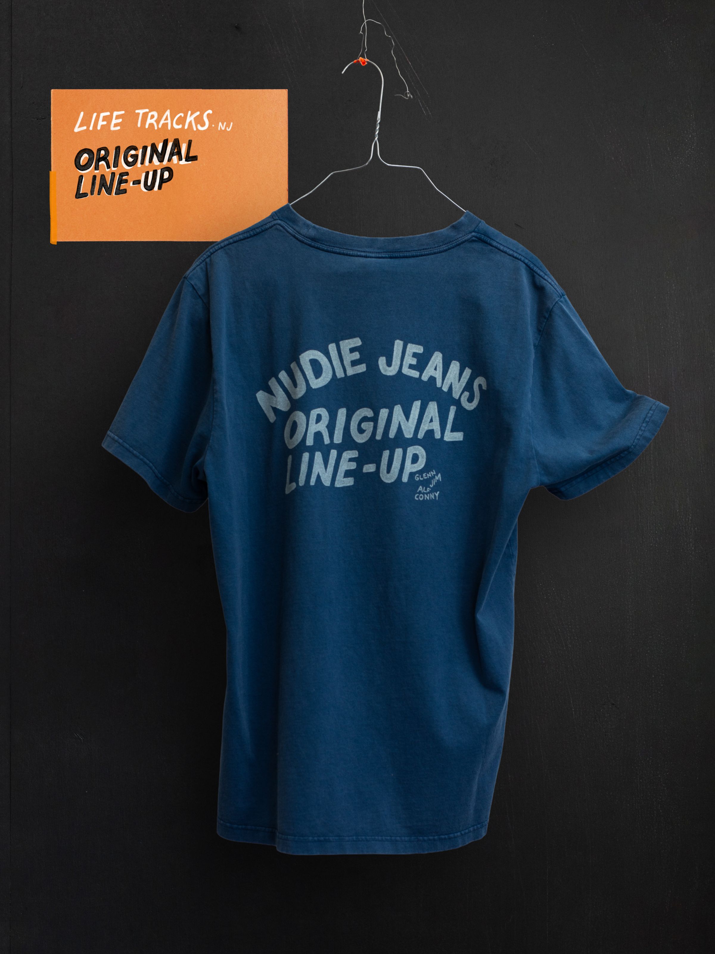 Nudie Jeans Roy T-Shirt OG Line-Up in French Blue, back view of the printed organic cotton tee on a wire hanger.