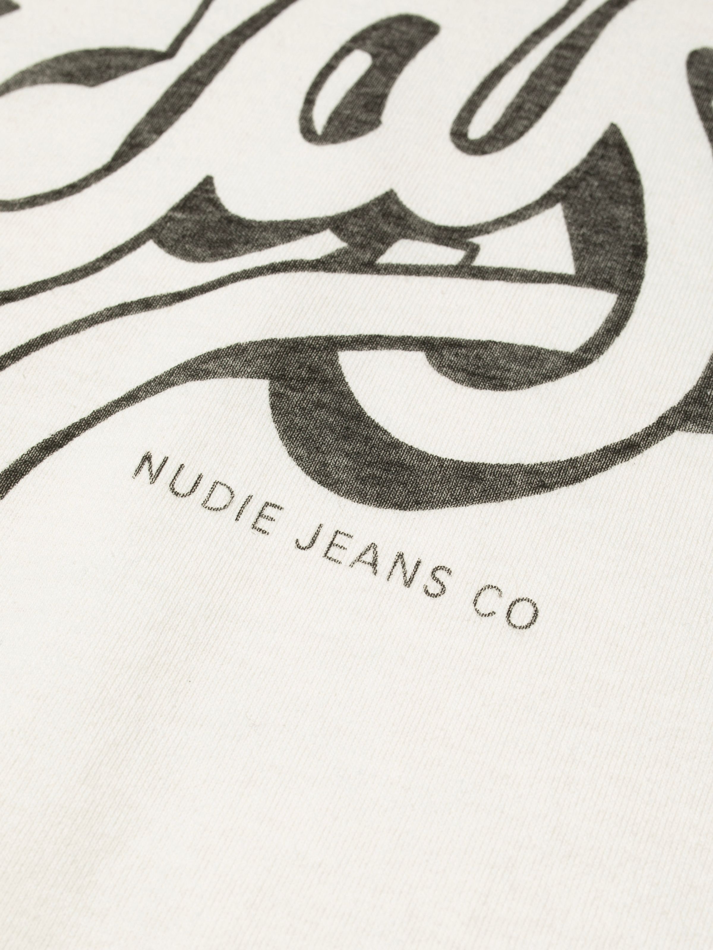 Nudie Jeans Roy Raglan T-Shirt Take It Easy, a close-up of the black chest print featuring the Nudie Jeans Co logo.