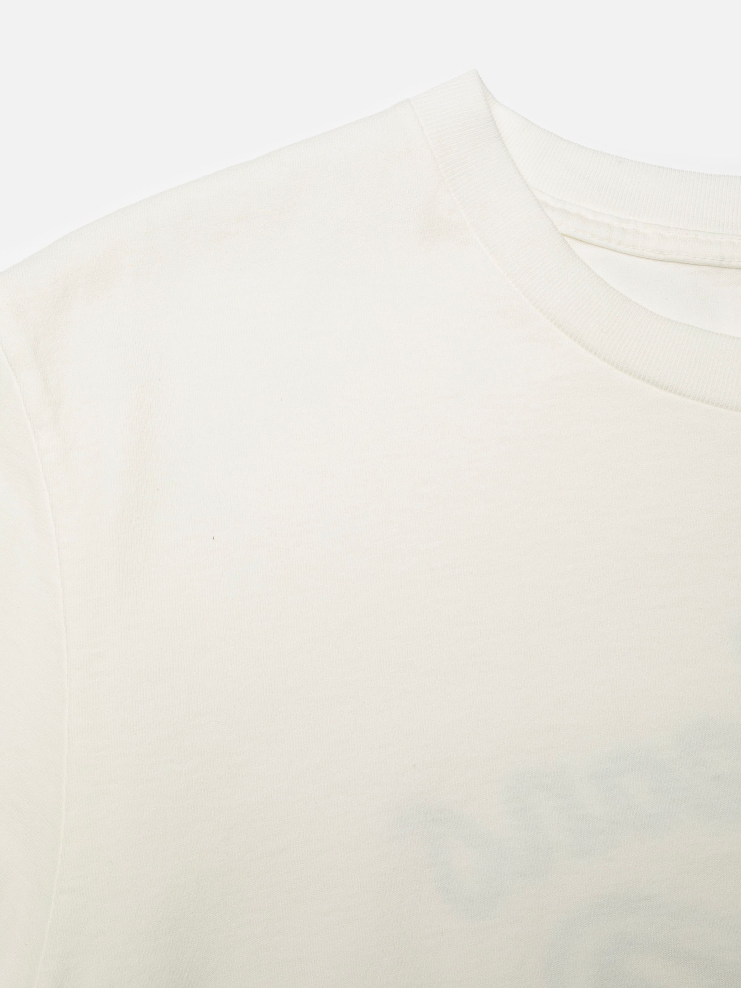 Nudie Jeans Roy T-Shirt NJCO Pin in Chalk White, close-up of the ribbed crew neck and organic cotton fabric.
