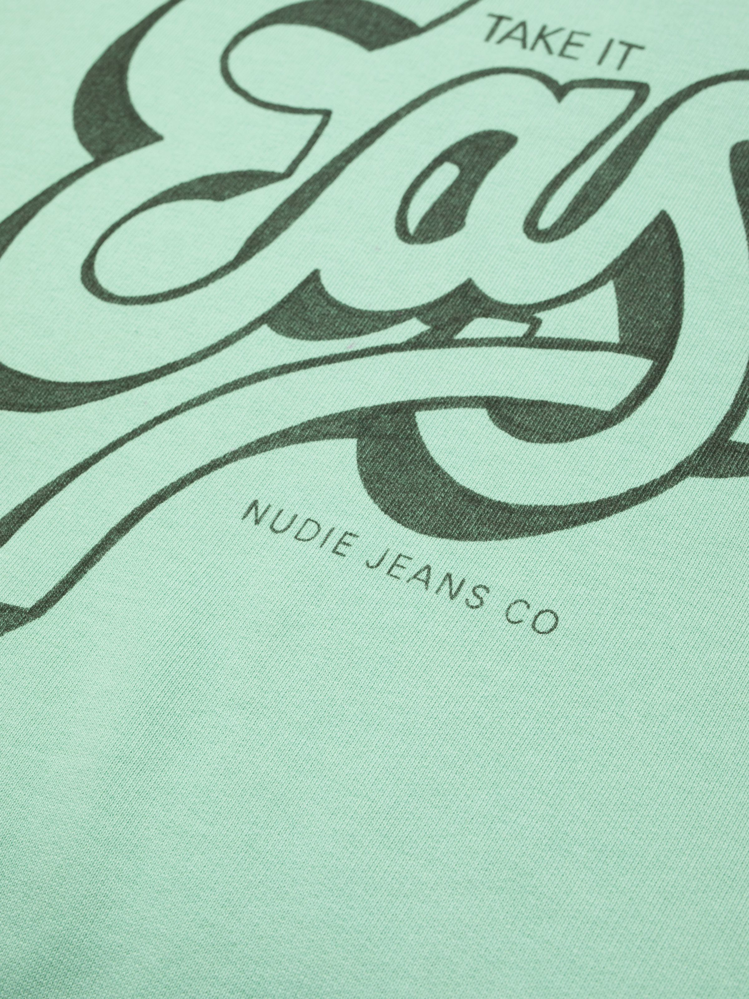 Nudie Jeans Palle Sweatshirt Take It Easy in Turquoise, close-up of the chest print showing Nudie Jeans Co text.