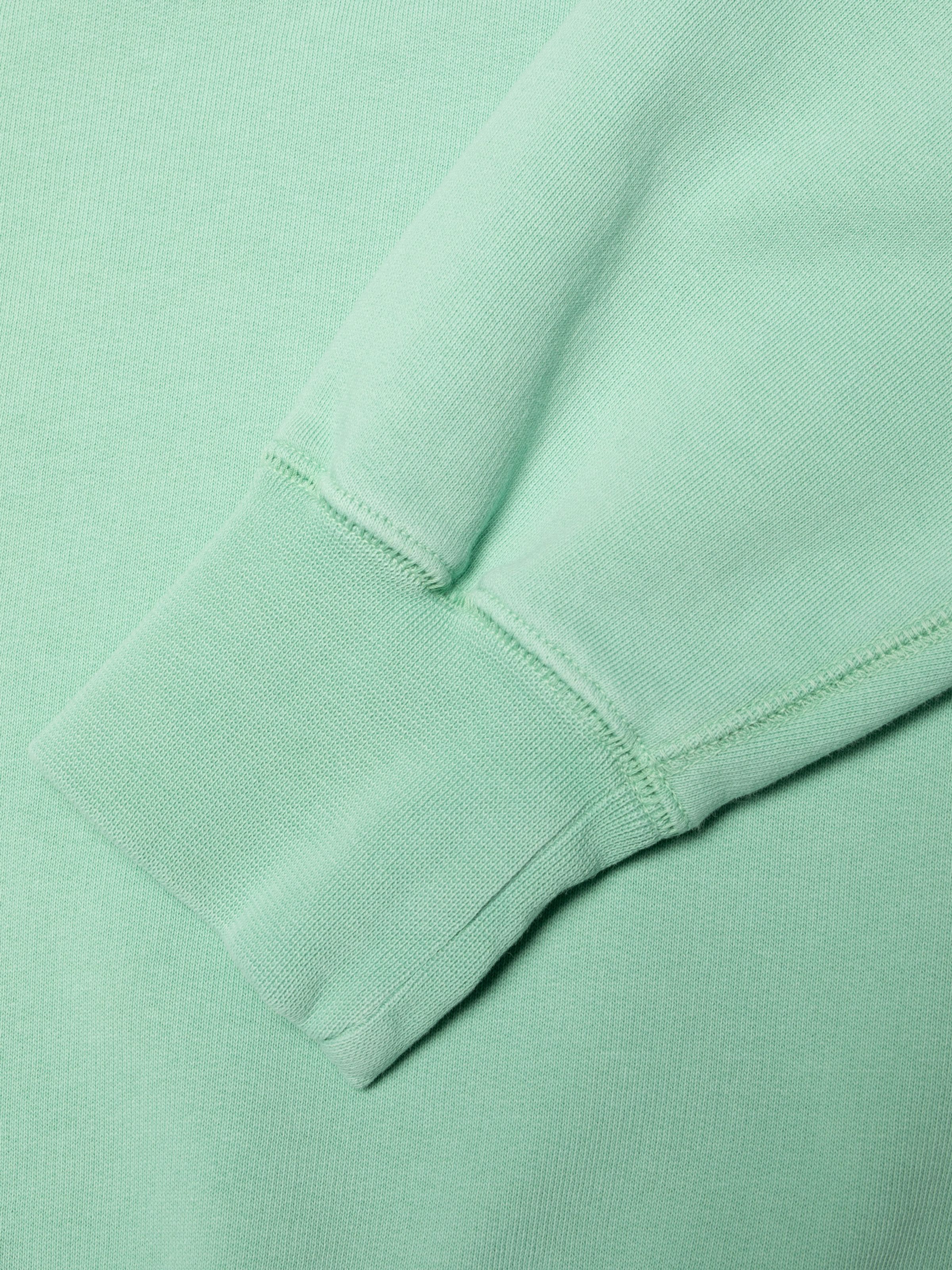 Nudie Jeans Palle Sweatshirt Take It Easy in Turquoise, close-up of the rib-knit cuff and flatlock seam.