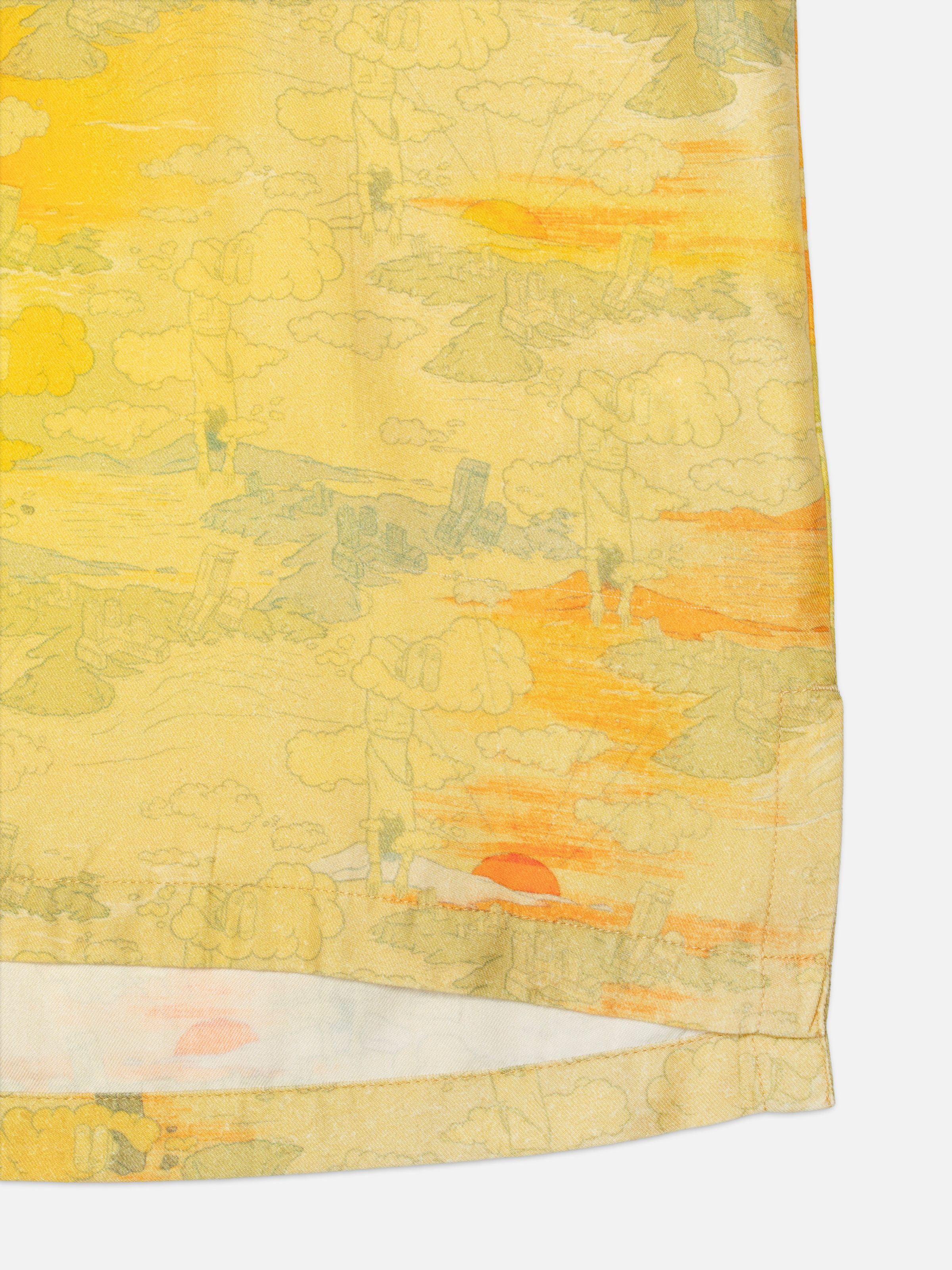 Nudie Jeans Arvid Hawaii Shirt Drift Away, close-up of the yellow surrealist print and the side-seam slit.