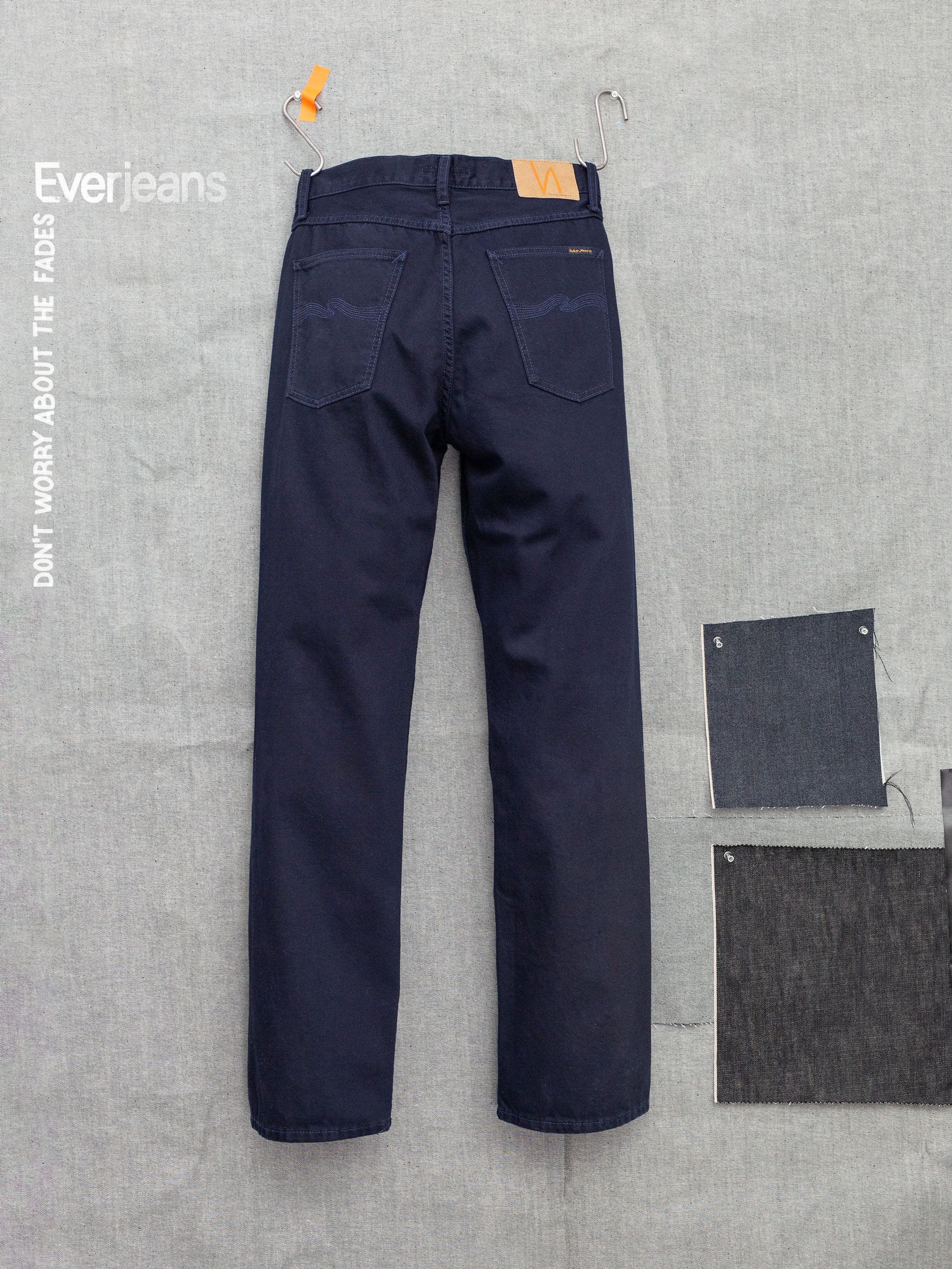 Nudie Jeans Tuff Tony Everblue loose wide-leg jeans in dark blue rigid denim, shown from the back with fabric swatches.
