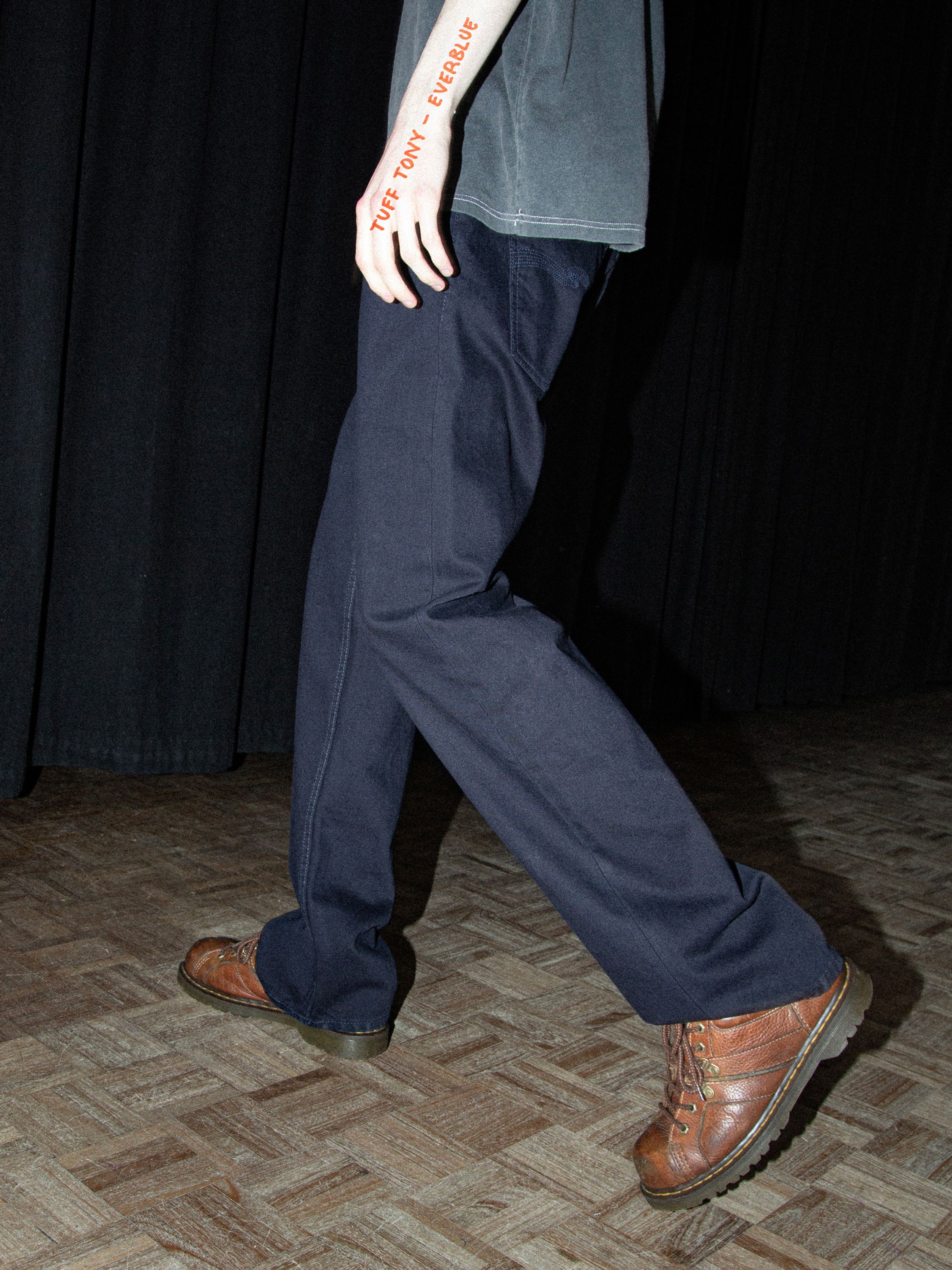 Nudie Jeans Tuff Tony Everblue, dark blue loose-fit wide-leg rigid denim jeans shown on a model walking.