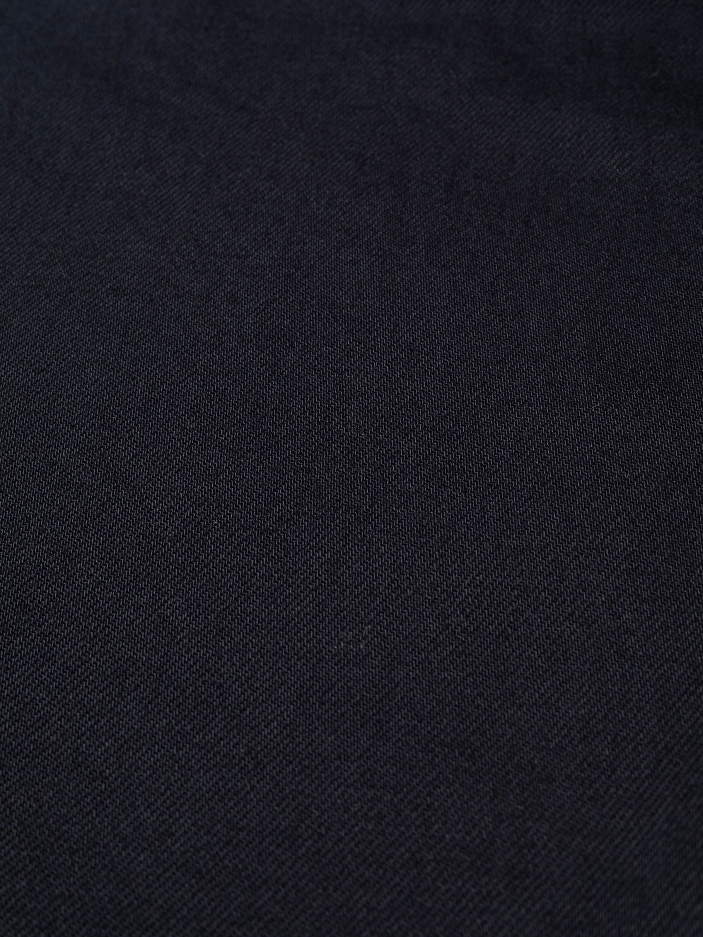 Nudie Jeans Tuff Tony Everblue, close-up of the dark blue organic regenerative cotton rigid denim fabric texture.