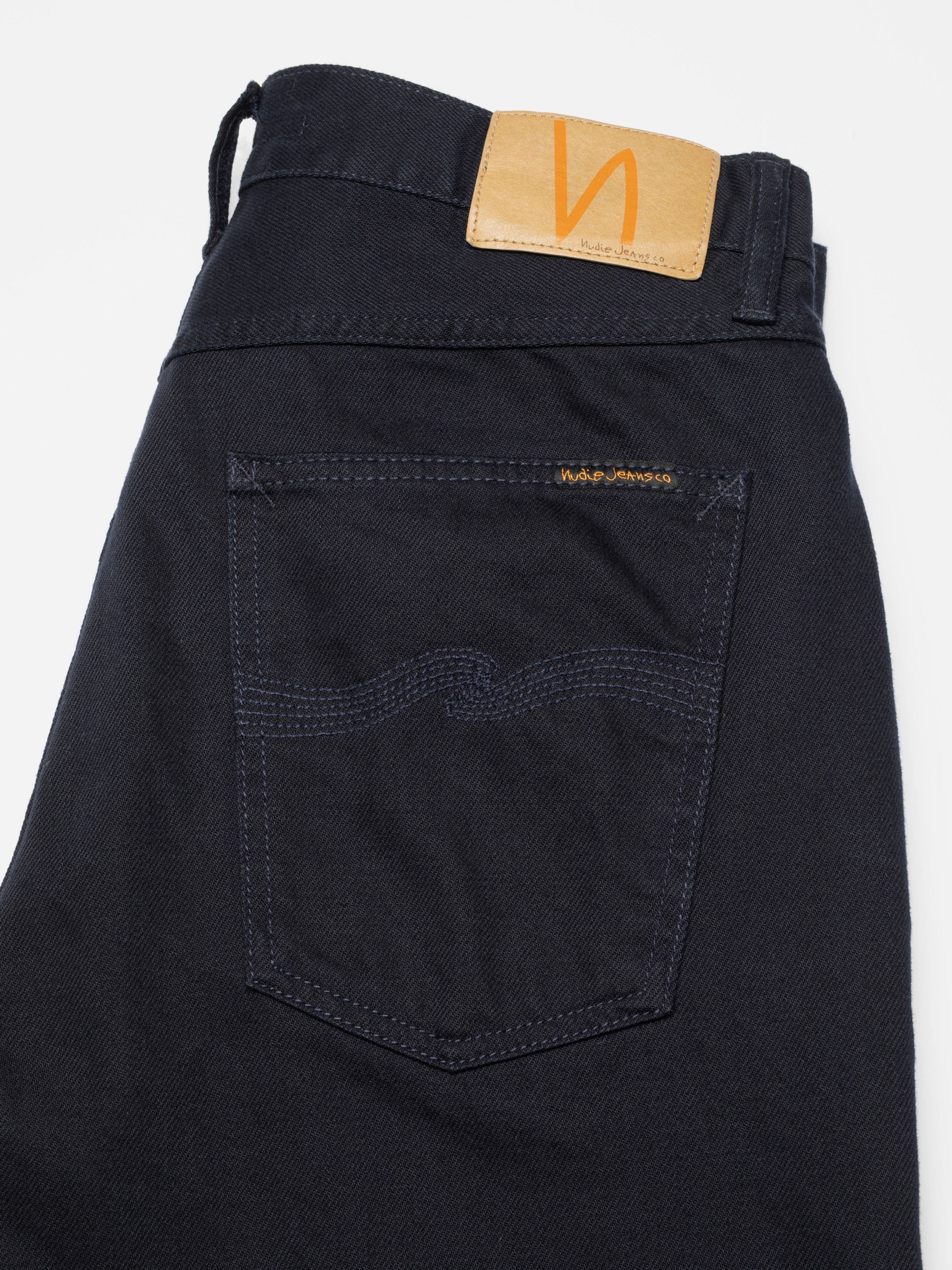 Nudie Jeans Tuff Tony Everblue, close-up of the back pocket with navy stitching and the Jacron patch.