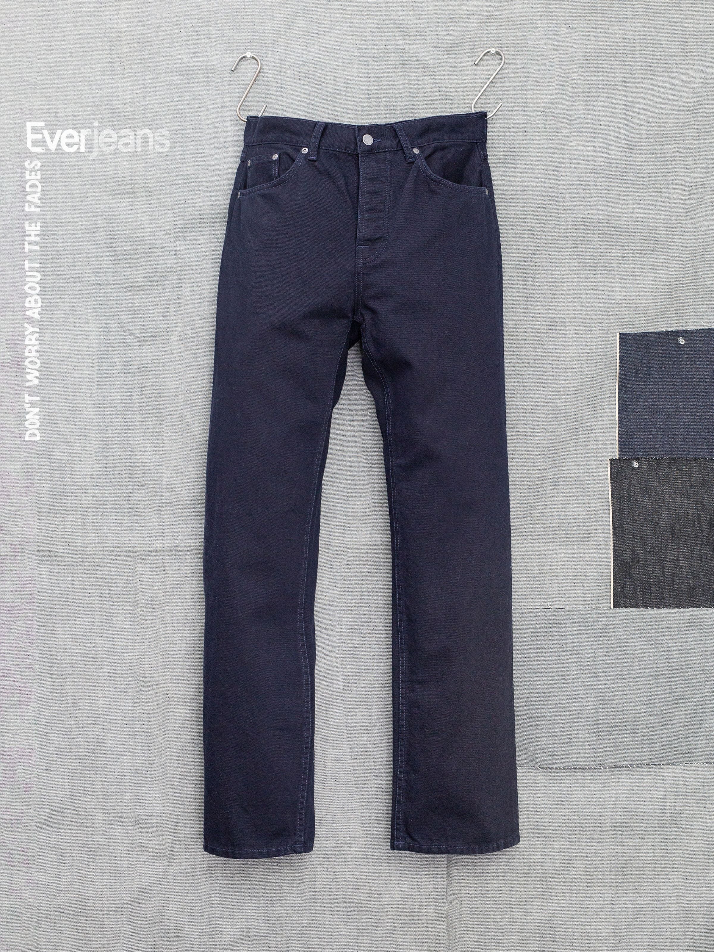 Nudie Jeans Tuff Tony Everblue, Jeans mit lockerer Passform aus dunkelblauem Rigid Denim, flach liegend mit Stoffmustern.