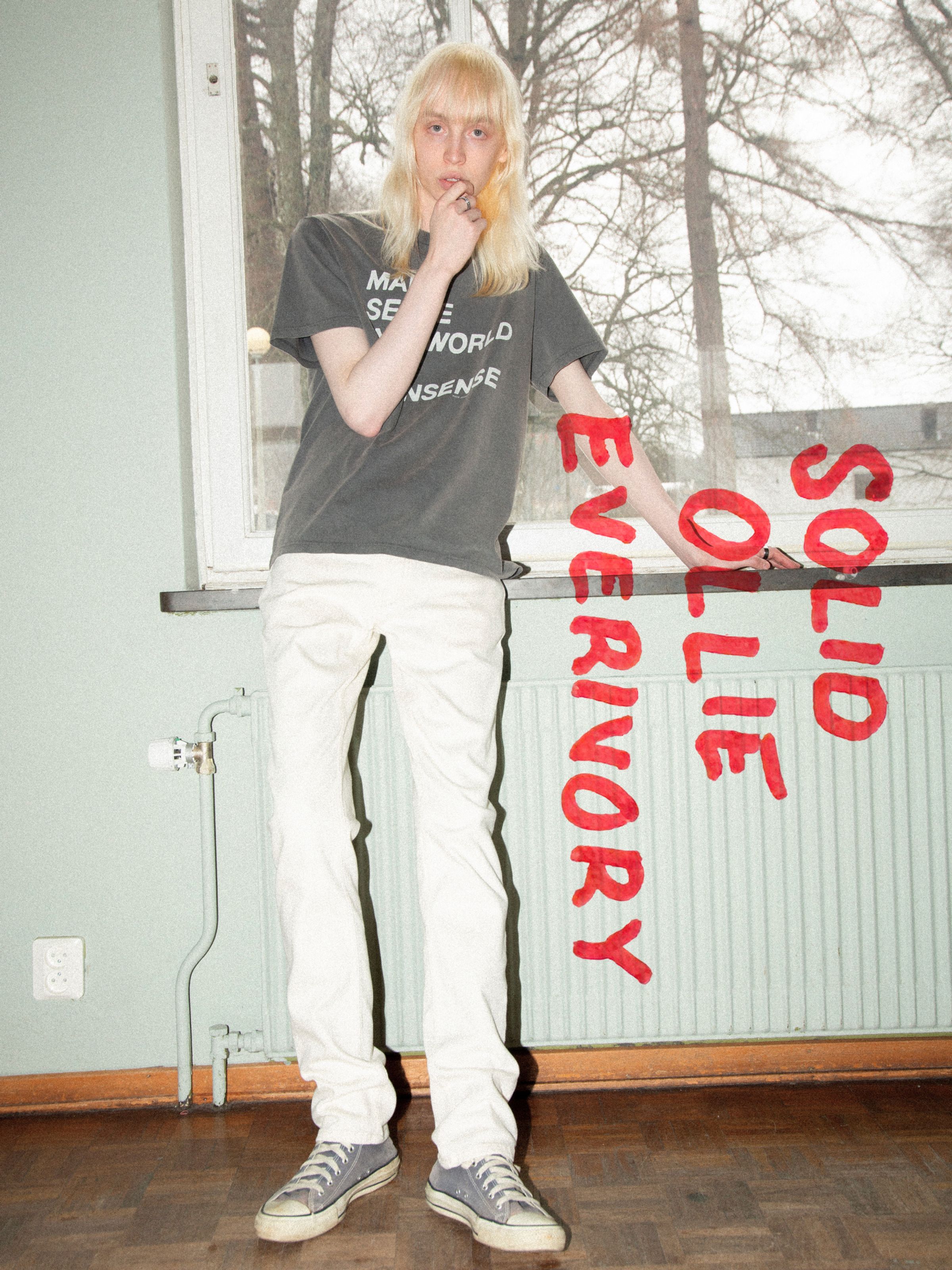 Nudie Jeans Solid Ollie Everivory, Herrenjeans mit schmaler Passform aus Ivory Stretch Denim in Lifestyle-Umgebung.