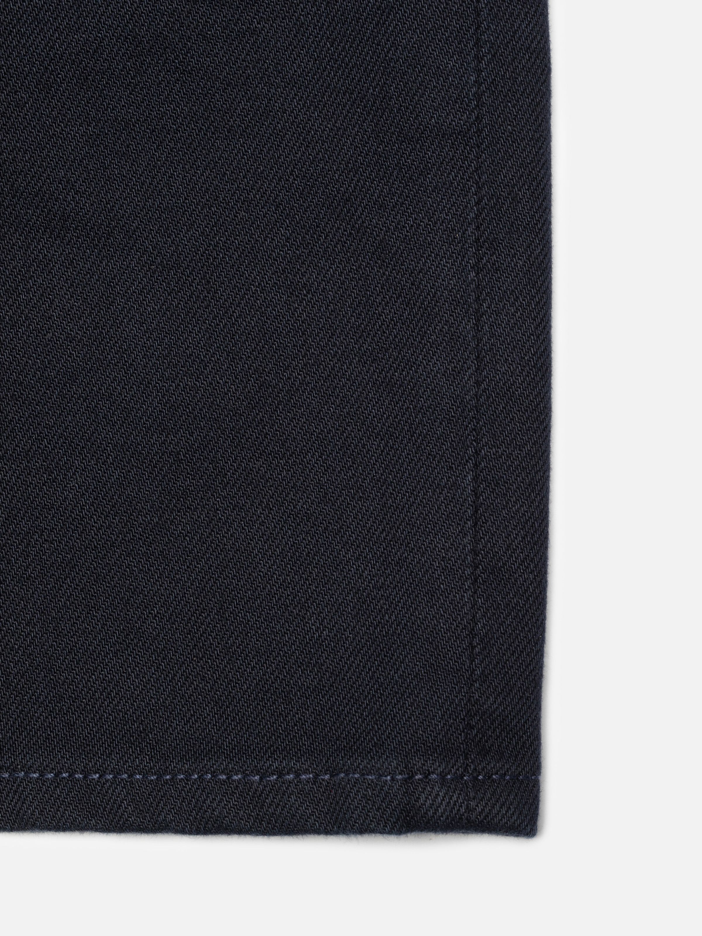 Nudie Jeans Seth Shorts Everblue, close-up of the dark blue rigid denim fabric and navy thread at the seams.