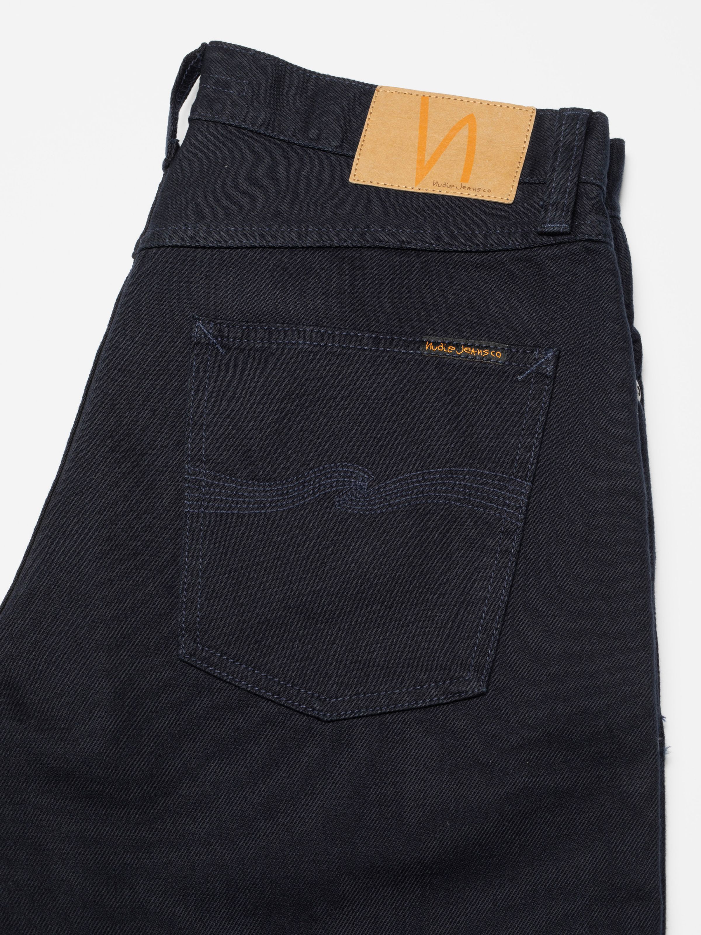 Nudie Jeans Seth Shorts Everblue, close-up of the back pocket showing tonal navy stitching and jacron patch.