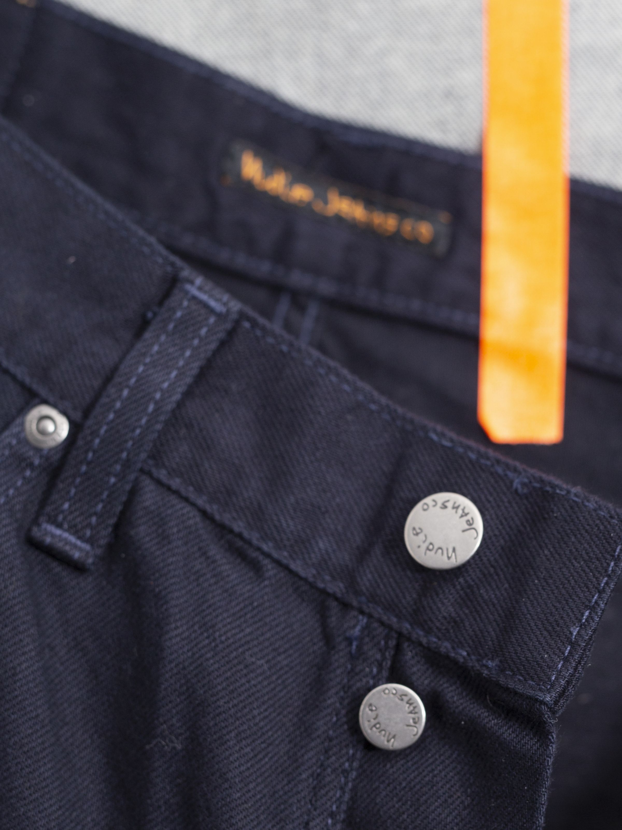Nudie Jeans Seth Shorts Everblue close-up, featuring the dark blue rigid denim and antique silver branded buttons.