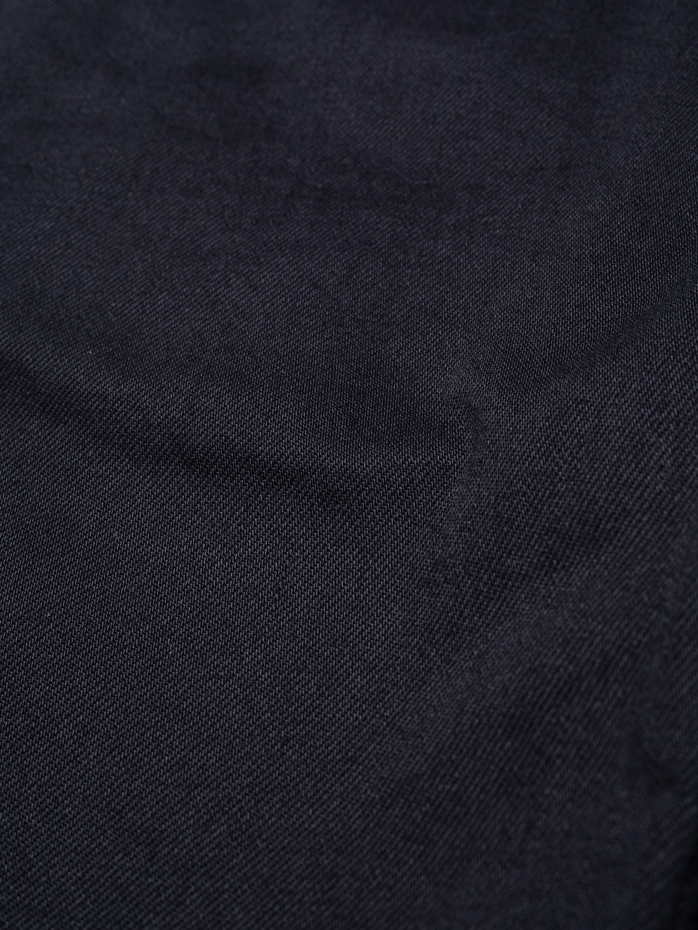 Nudie Jeans Seth Shorts Everblue, a close-up showing the texture of the 11 oz. dark blue rigid denim fabric.