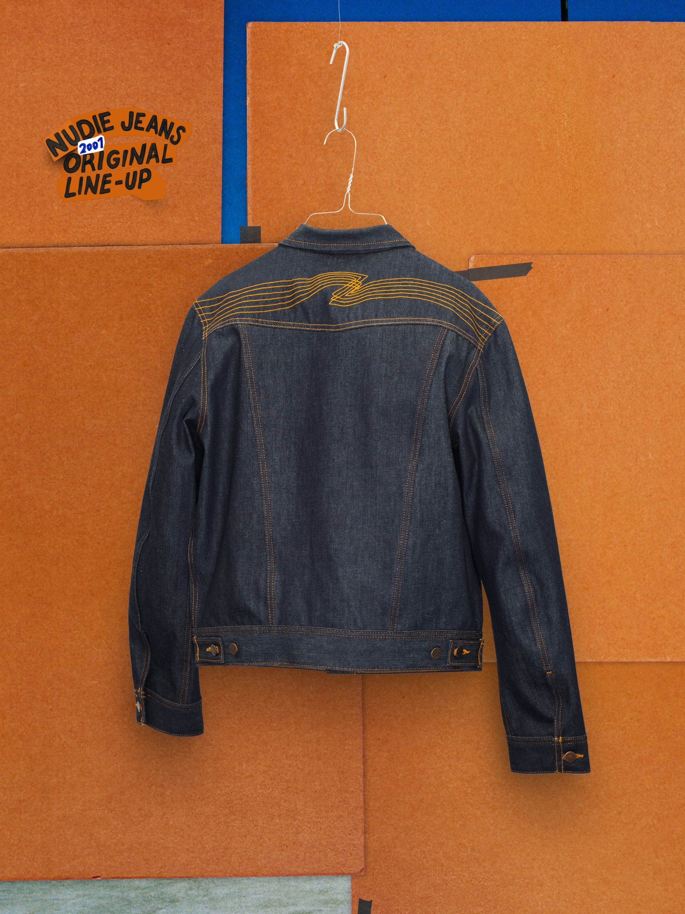 Nudie Jeans Conny Denim Jacket Dry One, back view showing the orange yoke embroidery on dark indigo rigid denim.