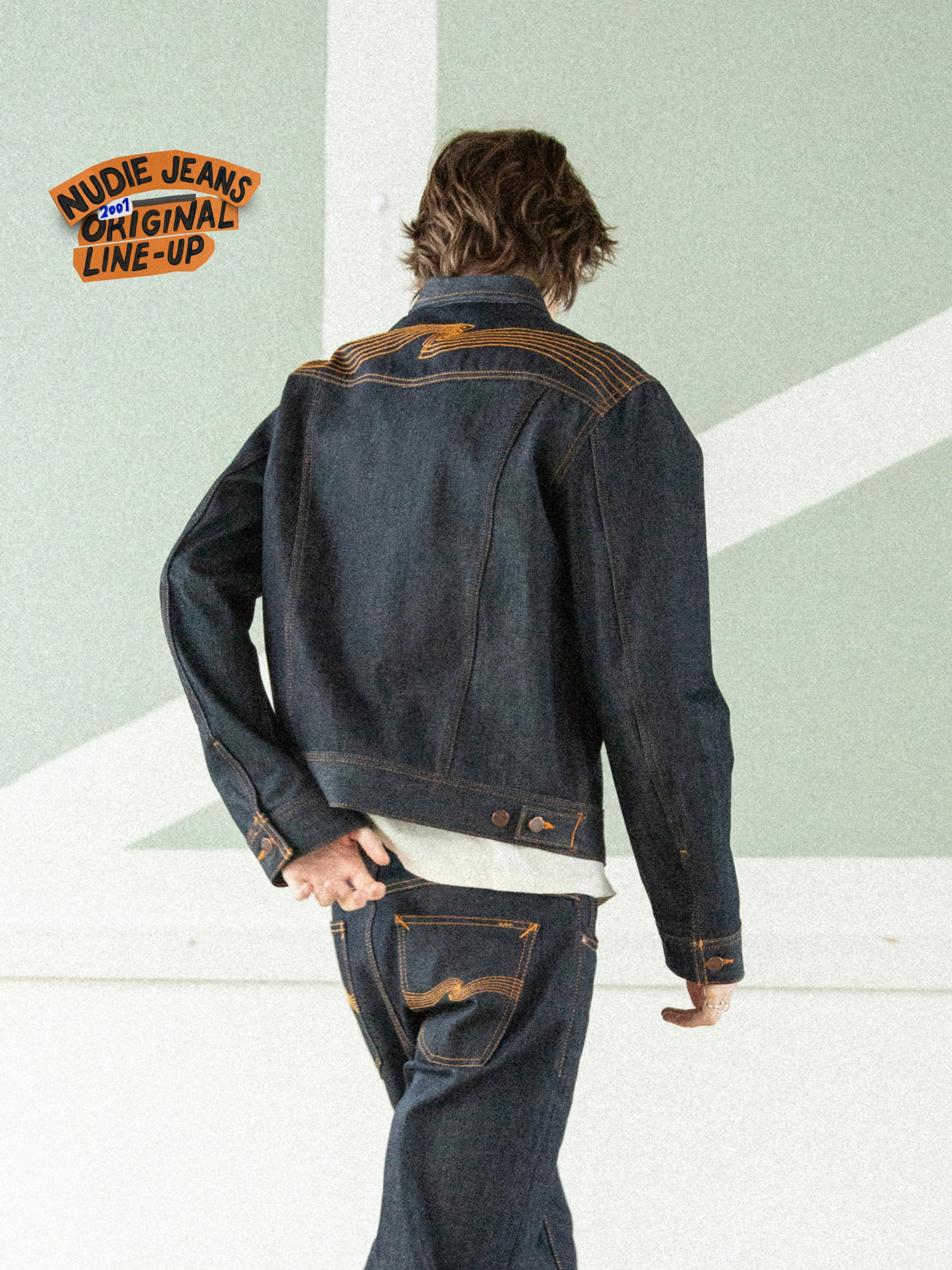 Conny Denim Jacket Dry One, a slim-fit rigid denim jacket with orange back yoke embroidery shown from behind on a model.