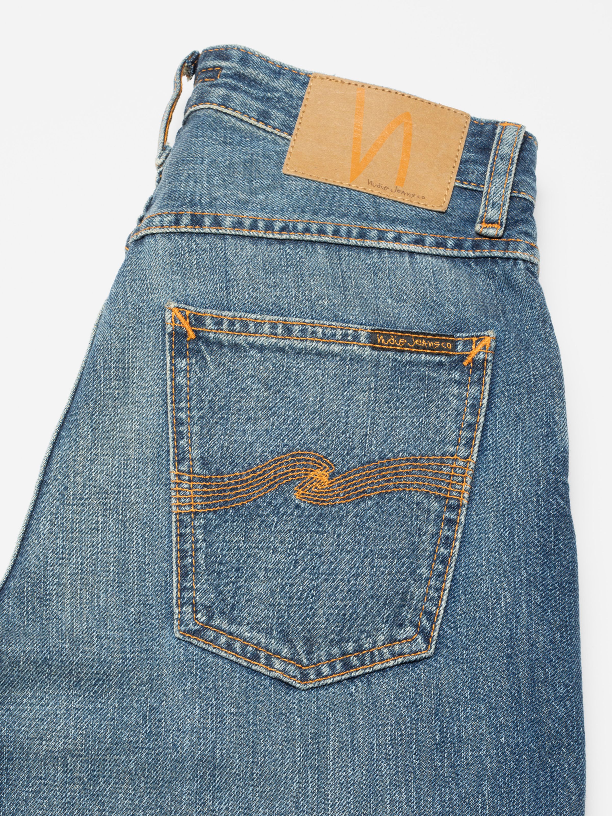 Nudie Jeans Clean Eileen Rust River, close-up of the back pocket with orange embroidery and jacron patch.