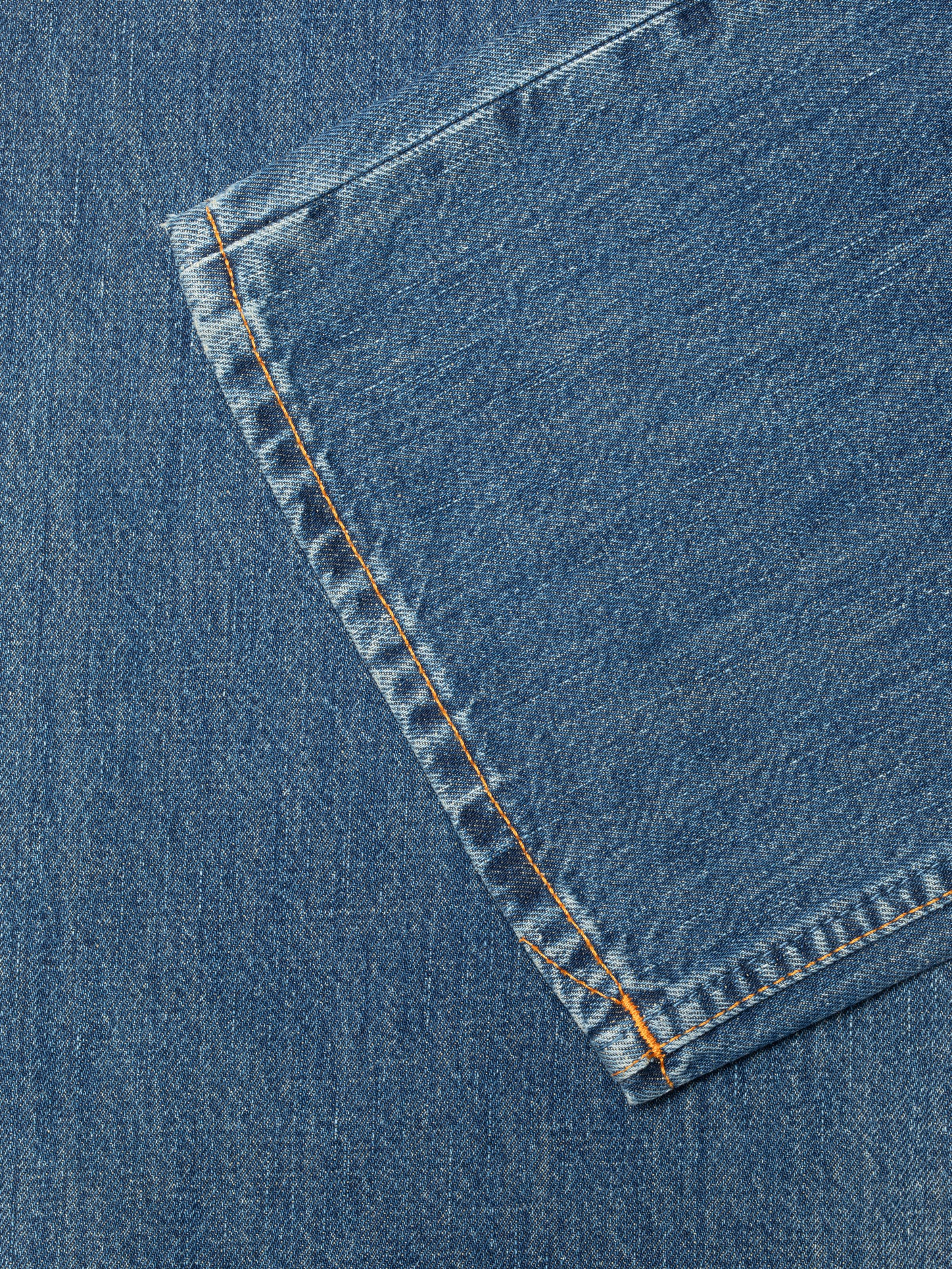 Nudie Jeans Clean Eileen Rust River, close-up of the back pocket featuring orange stitching.