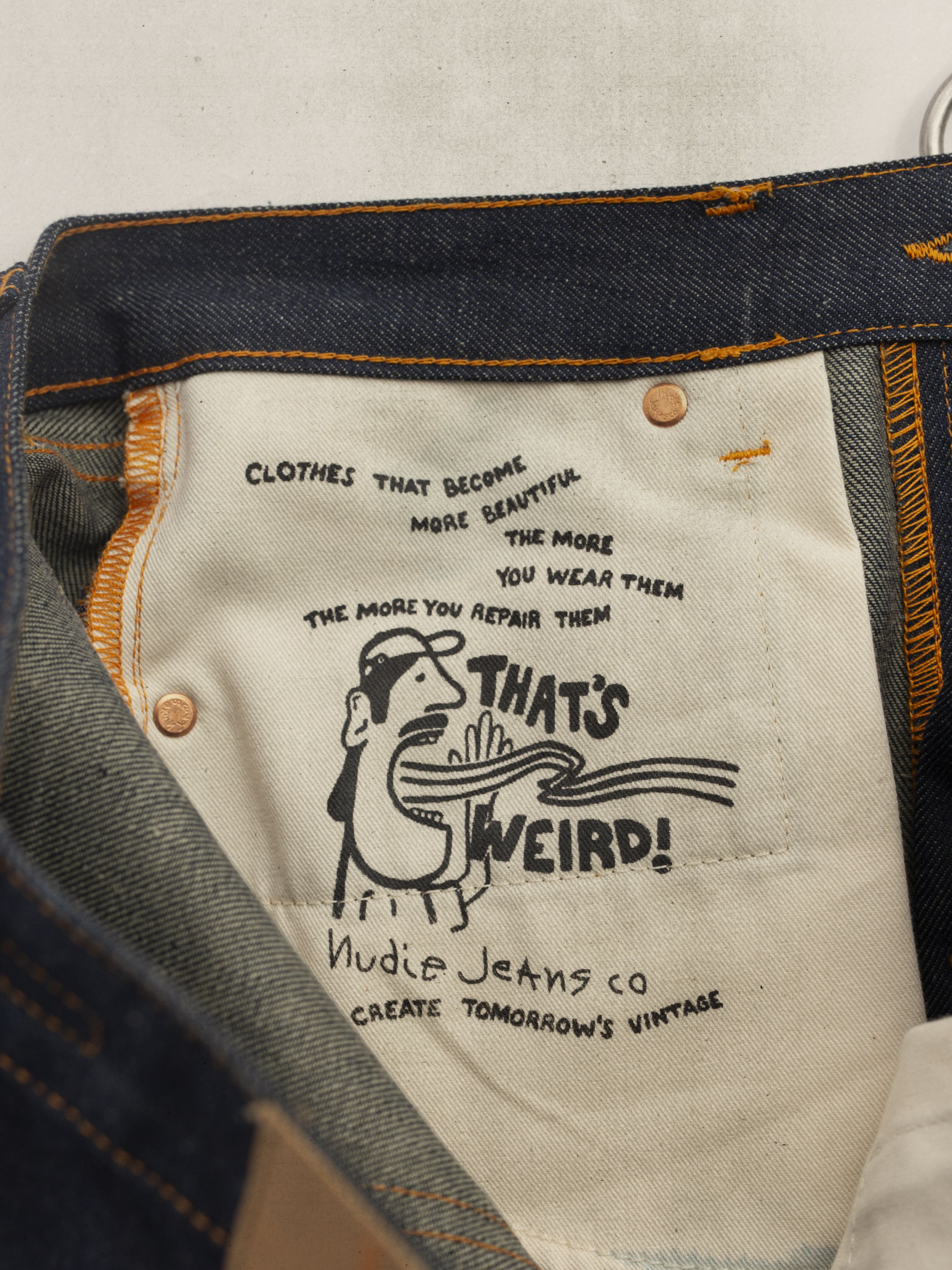 Nudie Jeans Rad Rufus Dry Weird, close-up of the white cotton pocket bag with the printed "That's Weird!" illustration.