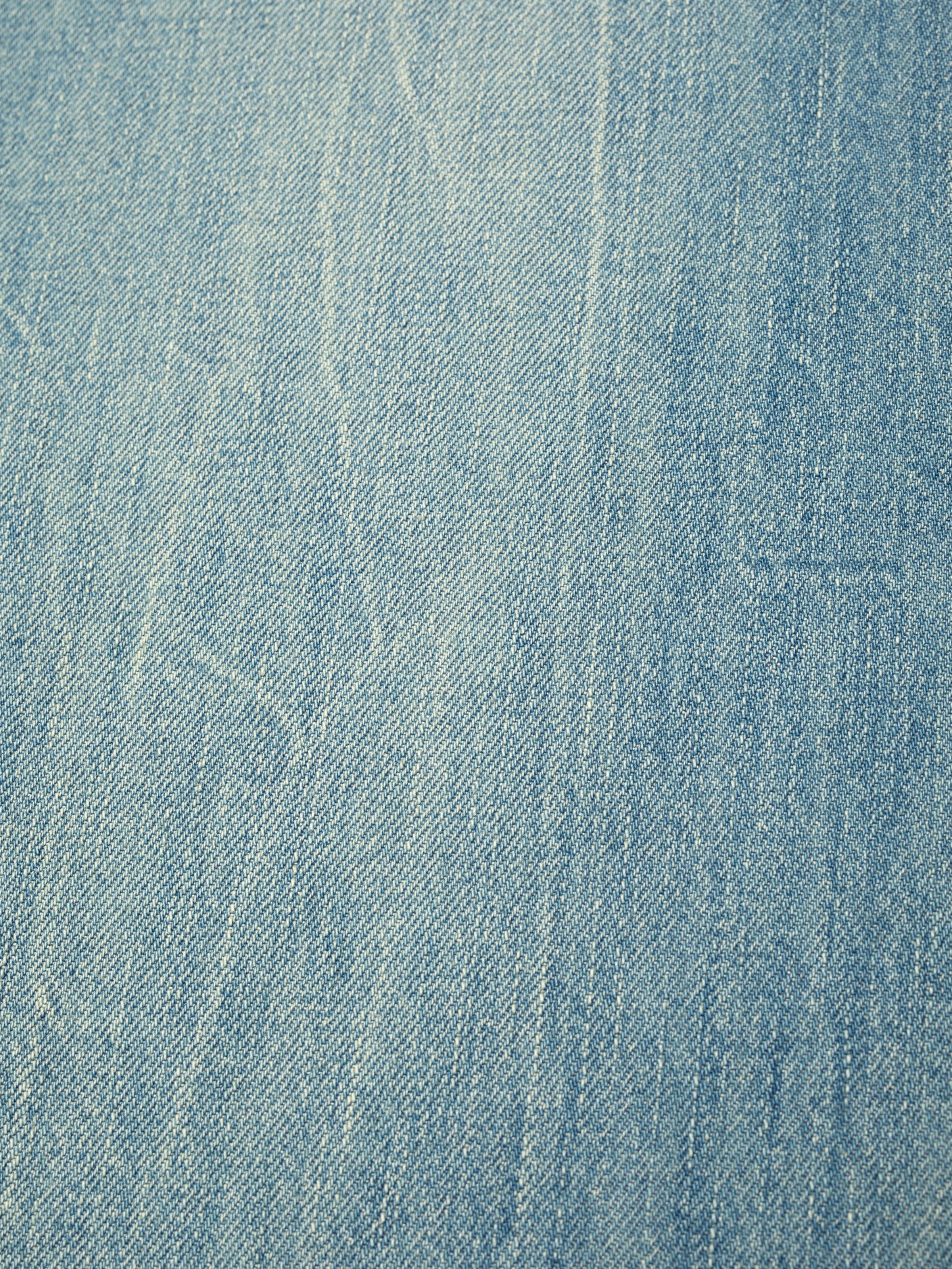 Nudie Jeans Wide Heidi Drift Wood, close-up of the light blue rigid denim fabric texture.