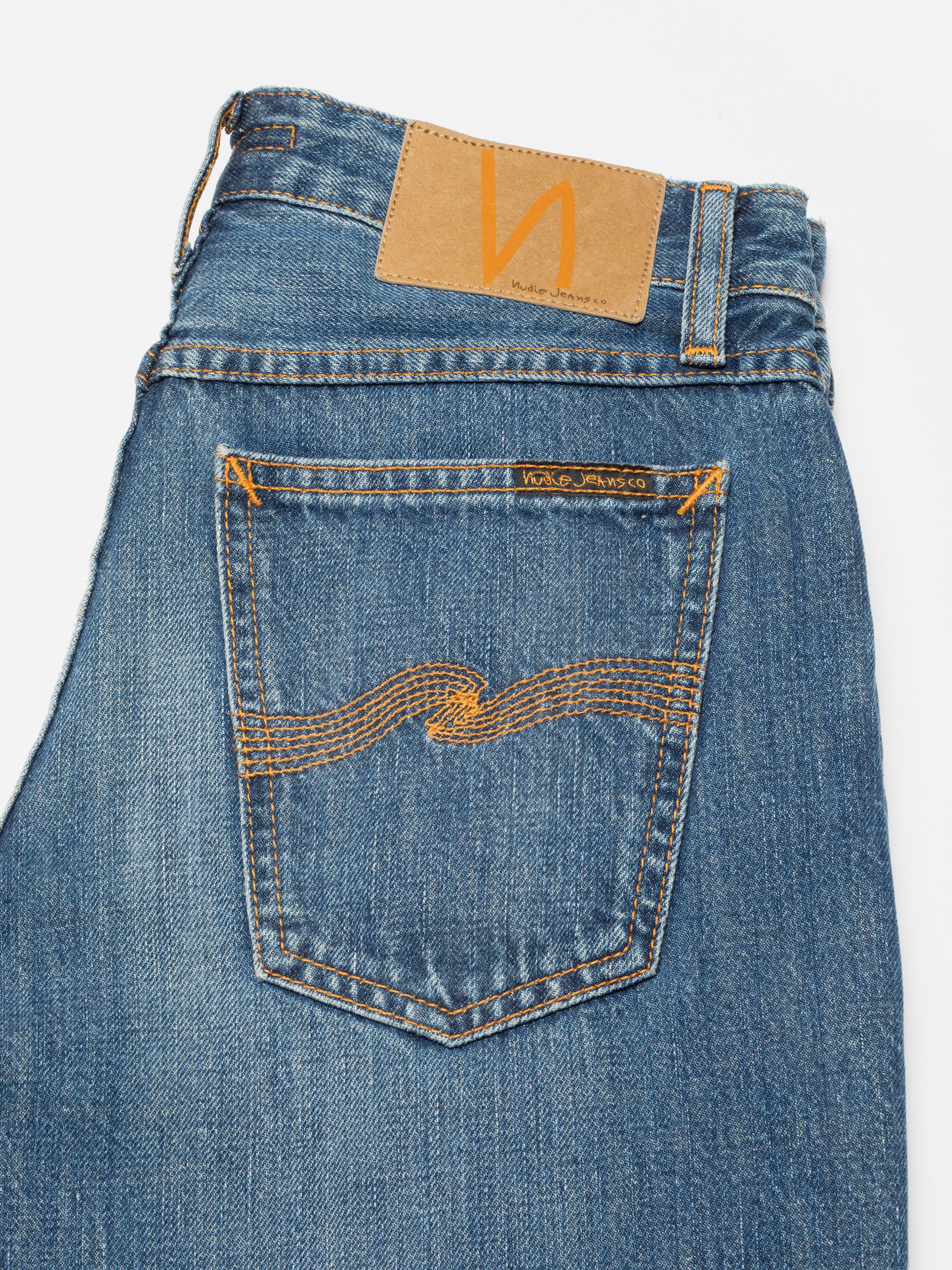 Nudie Jeans Dusty Dee Sierra Sun, close-up of the back pocket with orange embroidery and jacron patch.
