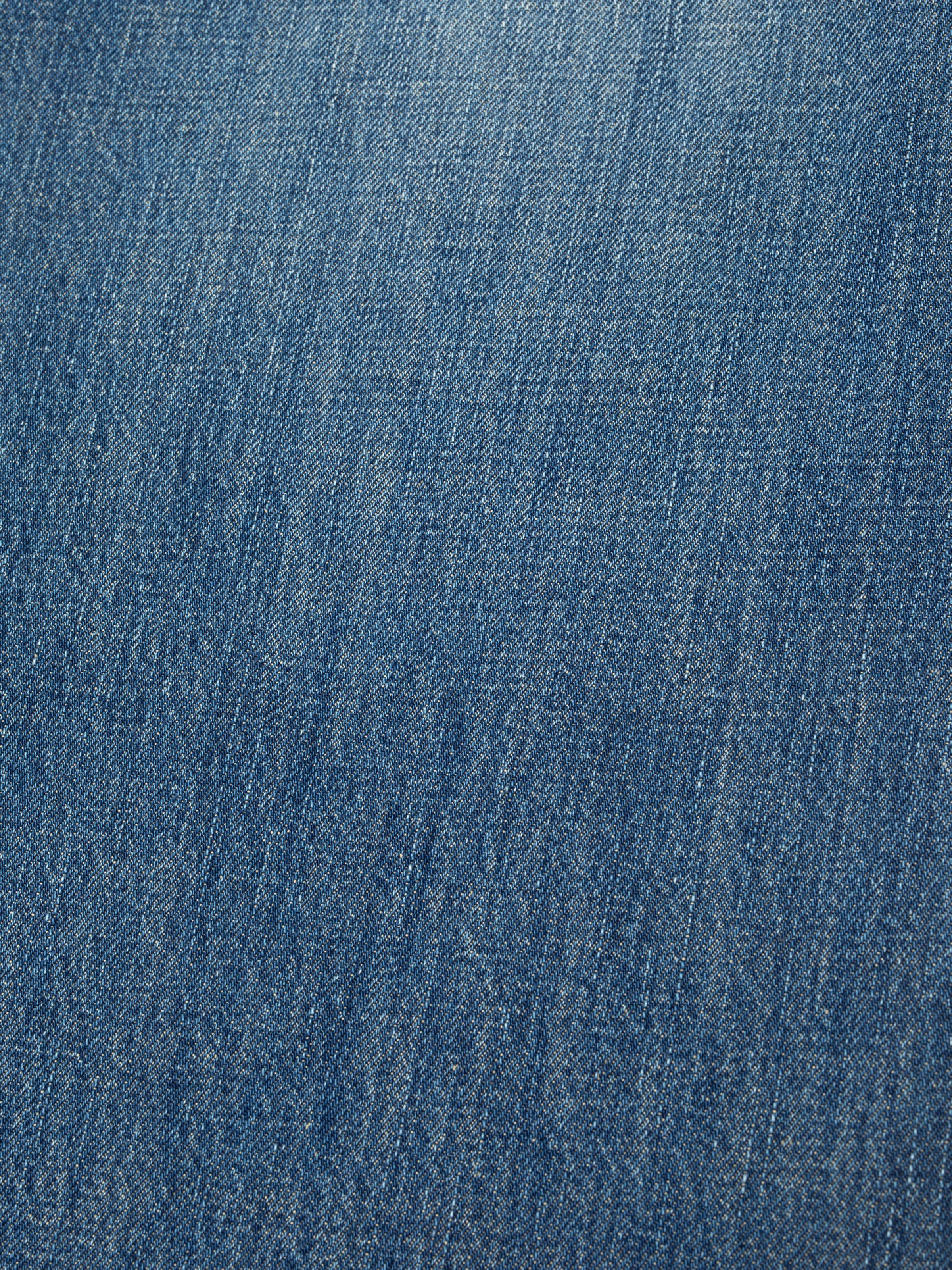 Nudie Jeans Dusty Dee Sierra Sun, close-up of the mid-blue rigid denim fabric texture.