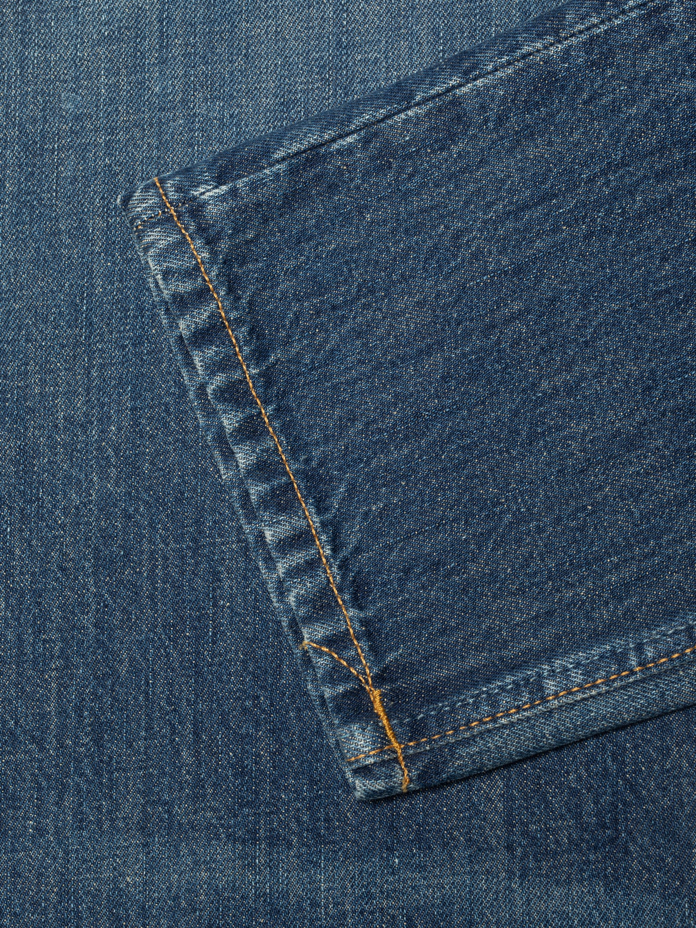 Nudie Jeans Steady Eddie II Indigo Dew, close-up of the leg opening and hem with tobacco stitching.