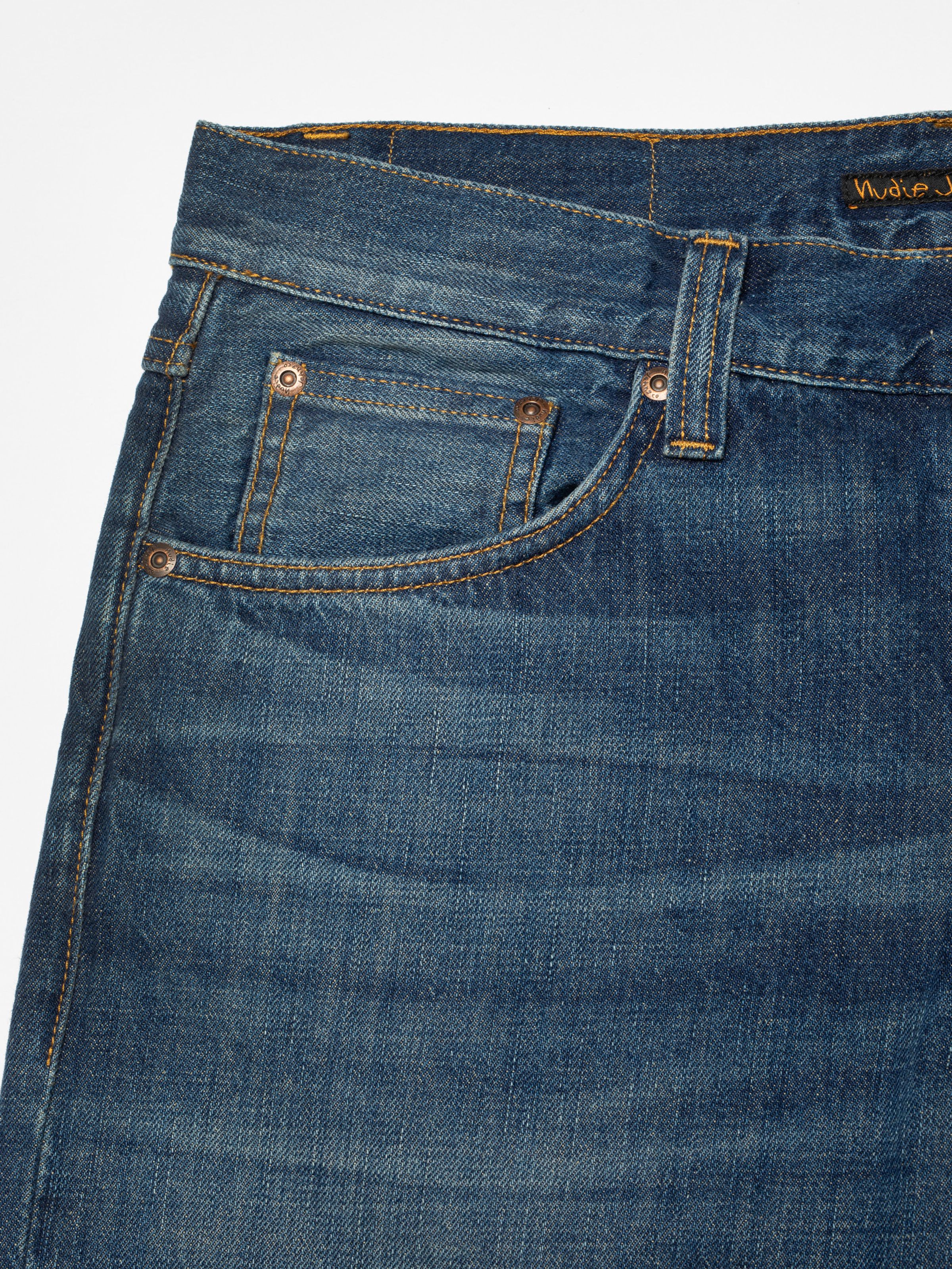Nudie Jeans Steady Eddie II Indigo Dew, close-up of the front pocket and copper rivets on mid blue rigid denim.